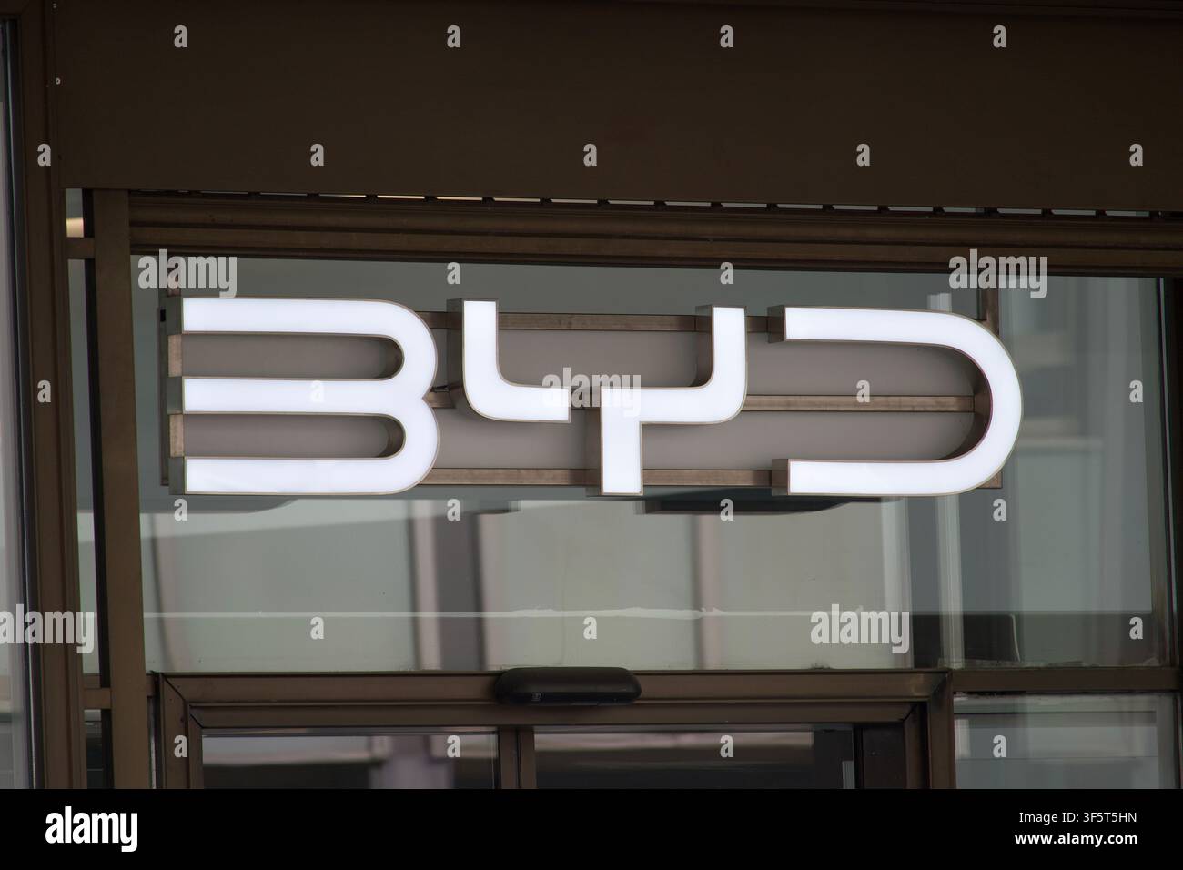 Zürich, Schweiz - 30. Juli 2026: BYD beleuchtetes Firmenlogo-Schild enge Frontnahaufnahme mit weißen 3D-Buchstaben, die über dem Glaseingang montiert sind Stockfoto