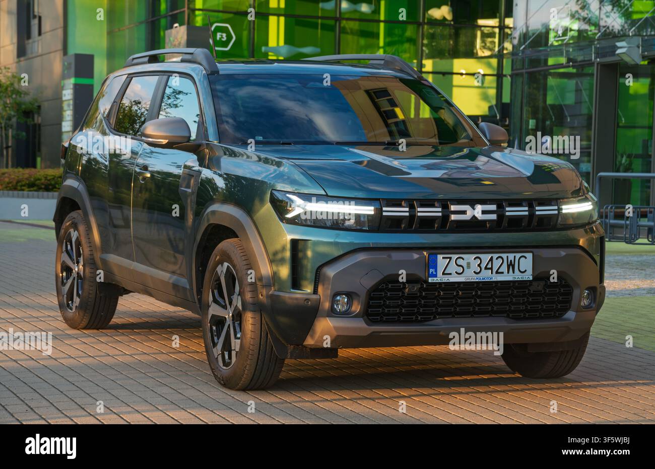 Der Dacia Duster der dritten Generation vor dem Hintergrund moderner Architektur Stockfoto