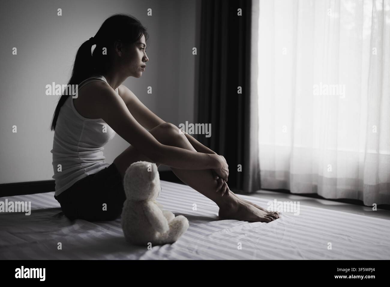 Traurige Frau sitzt allein. Bewusstsein für psychische Gesundheit, Unterstützung bei Depressionen, Bewusstsein für häusliche Konflikte, Frauensicherheit, Hoffnung, Genesung, Würde, Widerstandsfähigkeit Stockfoto