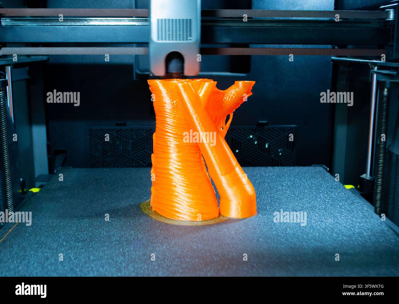 Prozessdruck auf 3D-Drucker. Der 3D-Druckprozess aus geschmolzenem orangefarbenem Kunststoff. 3D-Drucktechnologie. FDM-Technologien. Fused Deposition Modeling. Additives Fertigungsverfahren. Stockfoto