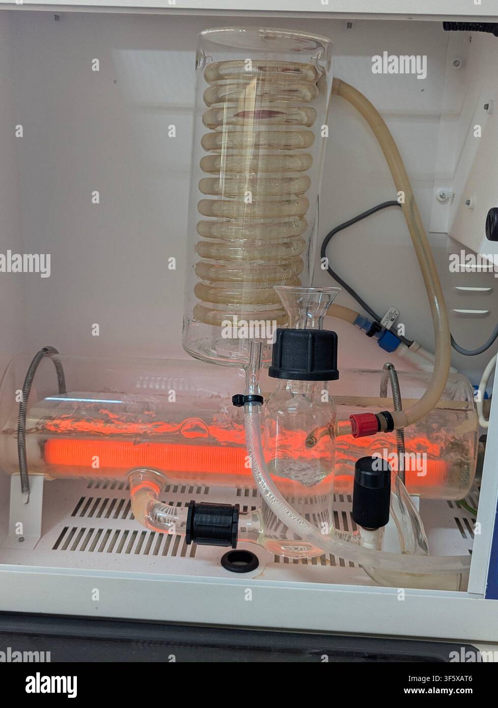 Eine laborgerechte Wasserdestillationsanlage mit einem horizontalen Borosilikatglas-Kessel und einem sichtbaren Heizer. - Smartphone-aufgenommenes Stockfoto