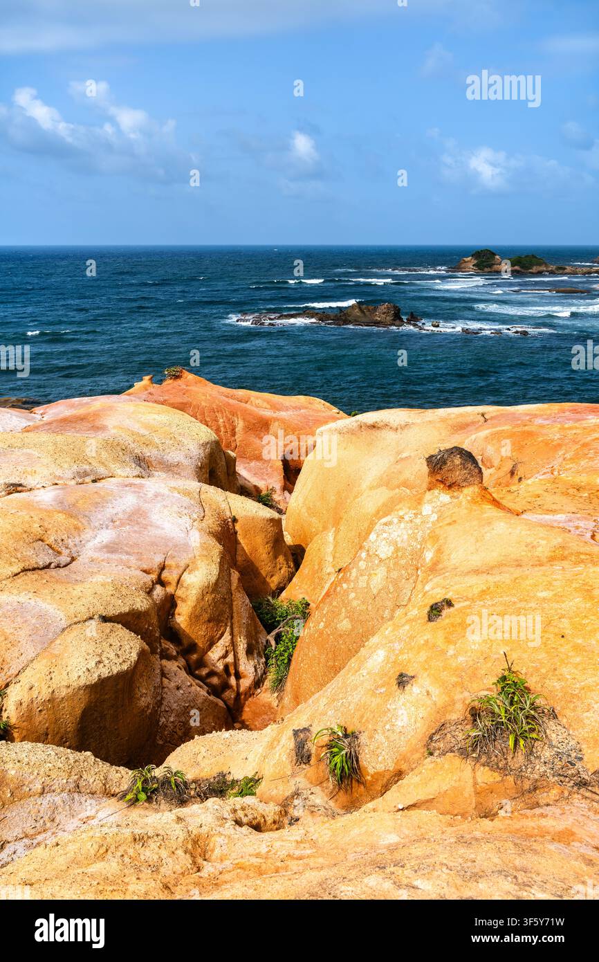Wunderschöner Blick auf die einzigartigen orangefarbenen und roten vulkanischen Felsformationen bei Red Rocks nahe Calibishie auf der Insel Dominica. Stockfoto