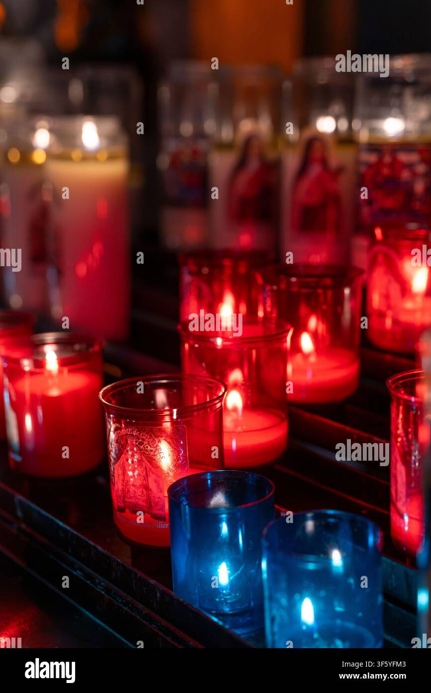 Votivkerzen in bunten roten und blauen Glasbehältern in der Kathedrale von Chartres - Kathedrale Unserer Lieben Frau von Chartres (Cathédrale Notre-Dame de Chartres). Stockfoto