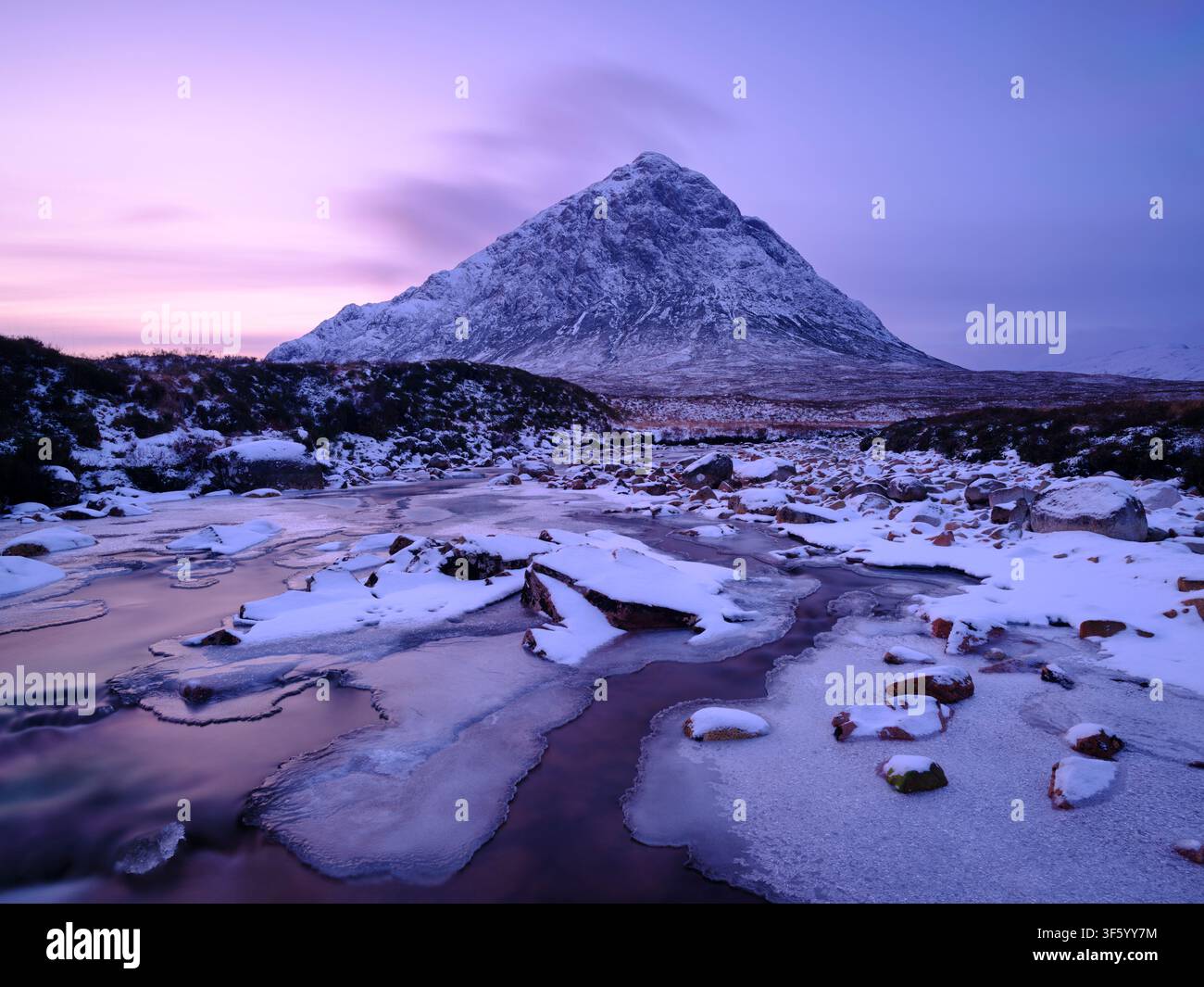 Schottland, schottische Highlands, Glencoe. Der Fluss Etive wird von dem imposanten Gipfel Buachaille Etive Mòr überragt, an einem Wintermittelalter am Abend. Stockfoto