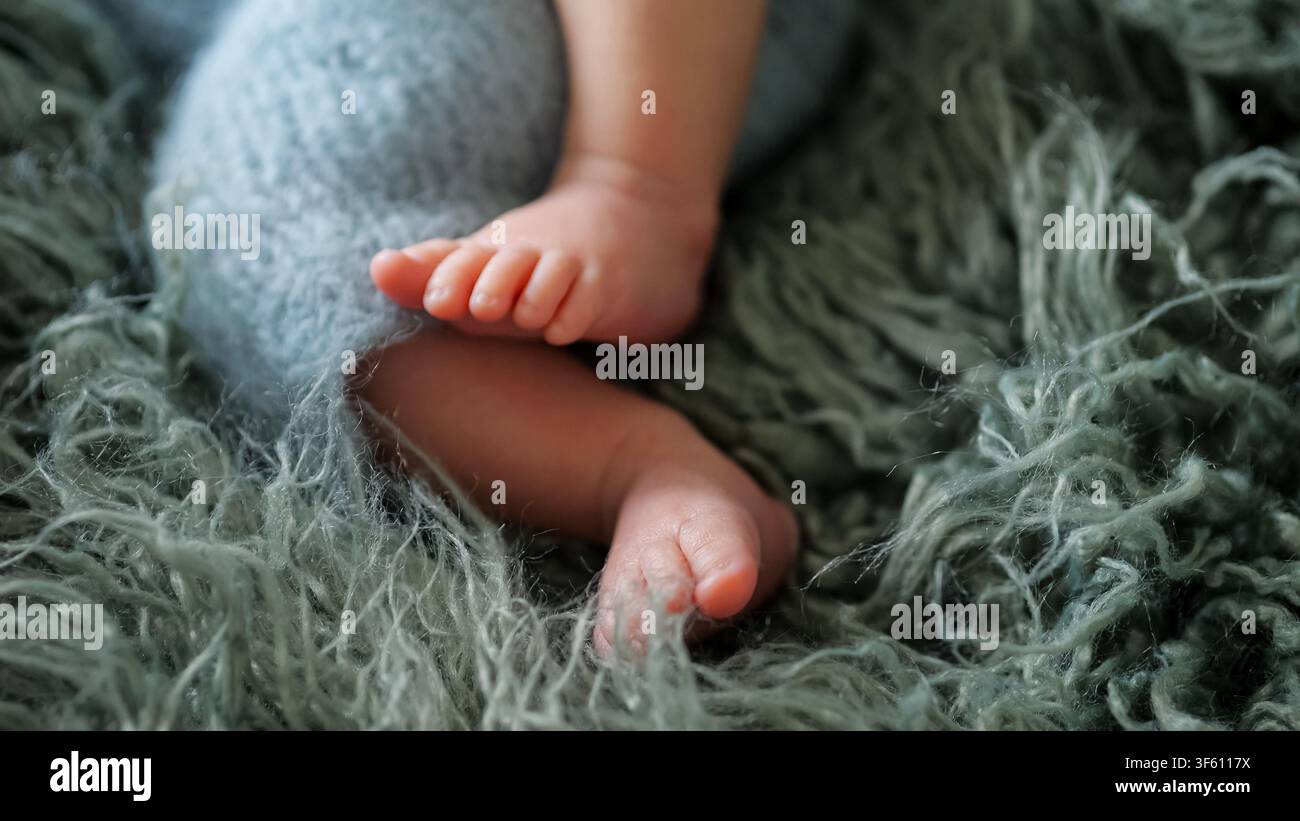 Neugeborene Babyfüße ruhen auf weicher flauschiger Decke Stockfoto