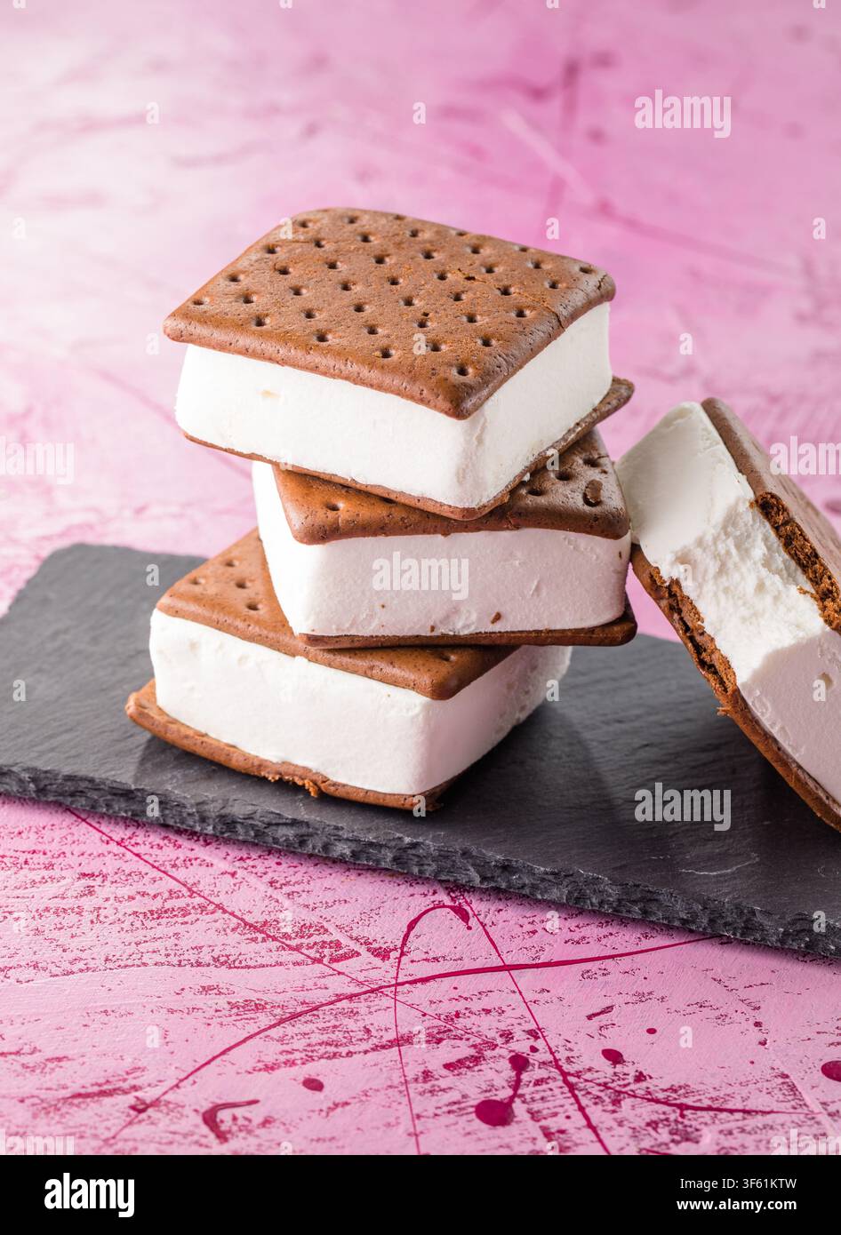Leckere Eiscremesandwiches auf rosa Tisch Stockfoto