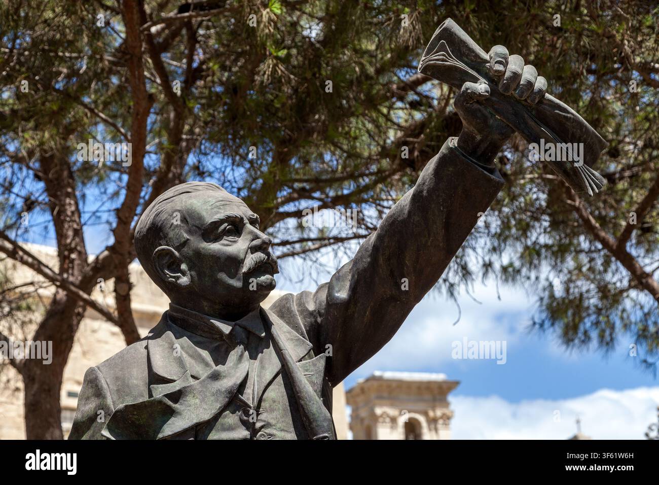 Bronzestatue von Manwel Dimech, maltesischer Sozialist und Sozialreformer, der seine Faust mit einem zusammengeballten Papier im Castille Square, Valletta, Malta erhebt Stockfoto