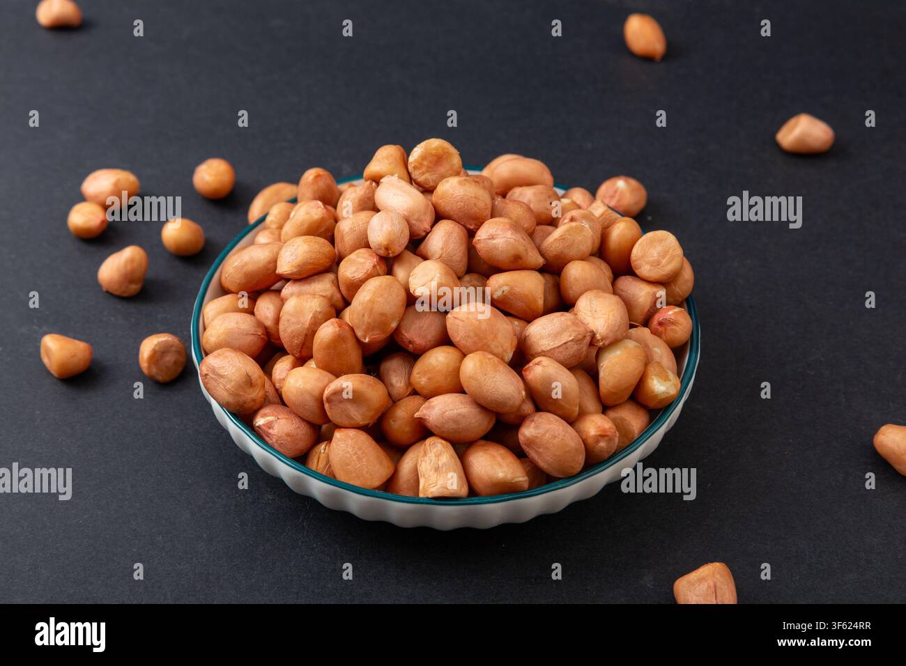 Rohe geschälte Erdnüsse mit roter Schale in Leinensack für Snack und kulinarisches Rezept Stockfoto
