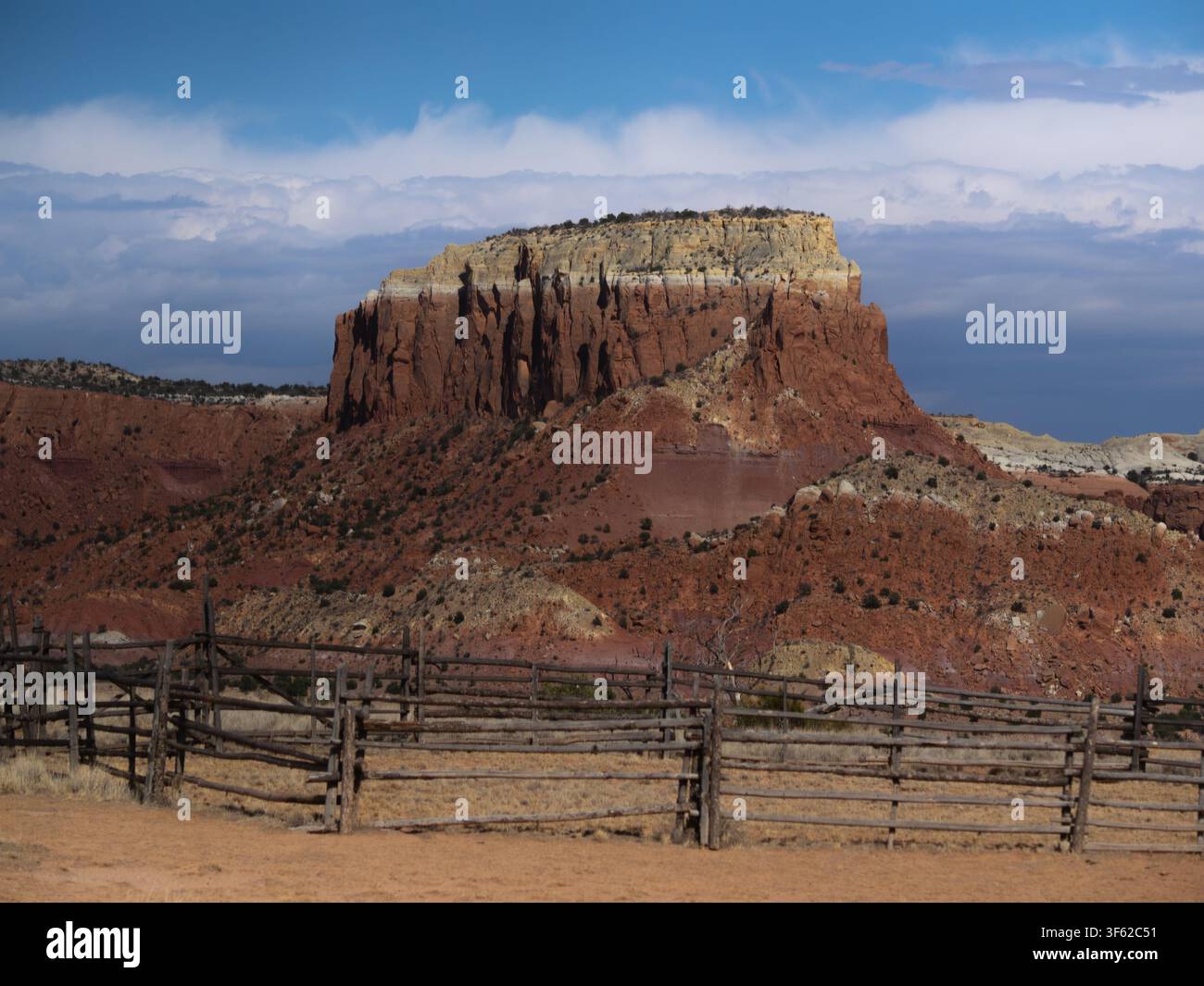 Schroffe rote Klippen erheben sich steil gegen einen bewölkten Himmel in Abiquiu, New Mexico, bei Ghost Ranch Stockfoto
