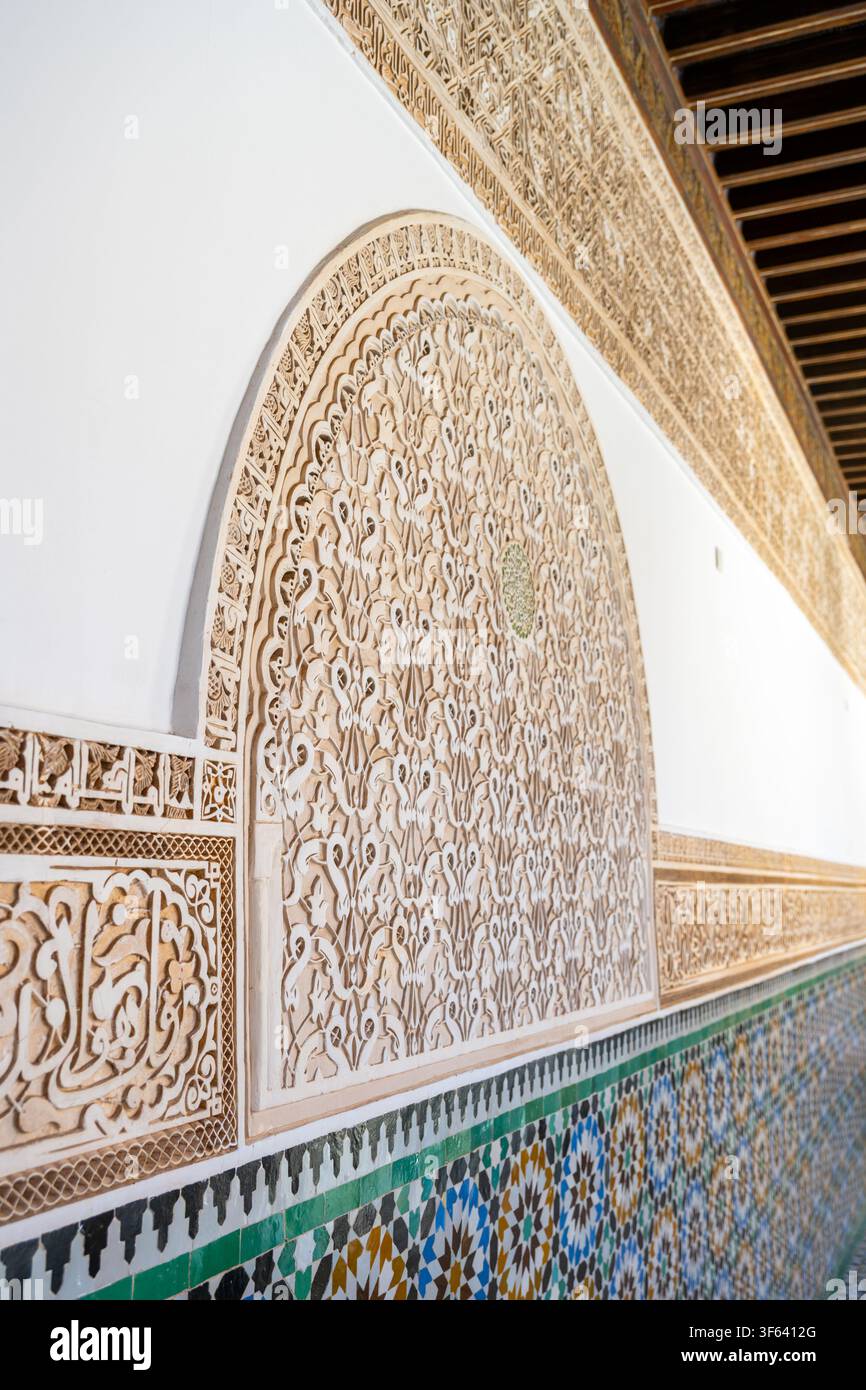 Die detaillierte Arbeit aus geformtem Gips zeigt kunstvolle Designs an den Wänden der Madrasa Ben Youssef in Marrakesch. Dieser historische Ort spiegelt reiches kulturelles Erbe und Kunstfertigkeit wider. Stockfoto