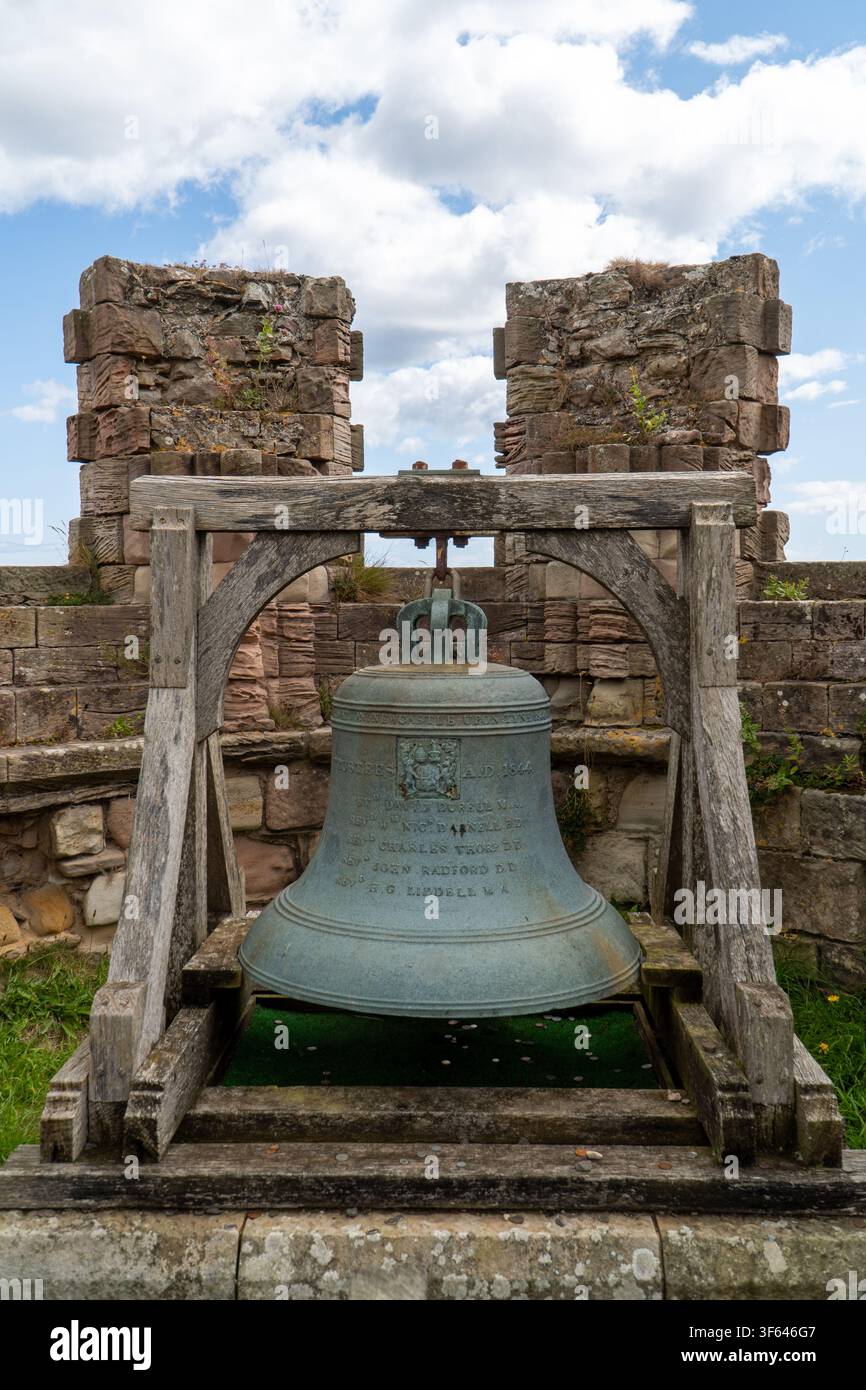 Eine historische Glocke in den Ruinen von Bamburgh Castle in Northumberland, England. Stockfoto
