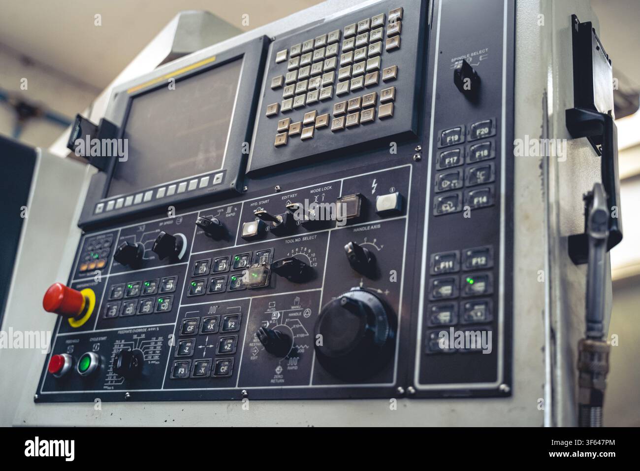 Winkelansicht einer industriellen CNC-Drehmaschinensteuerung mit Tasten, Schaltern und Reglern in einer automatisierten Fertigungsanlage Stockfoto