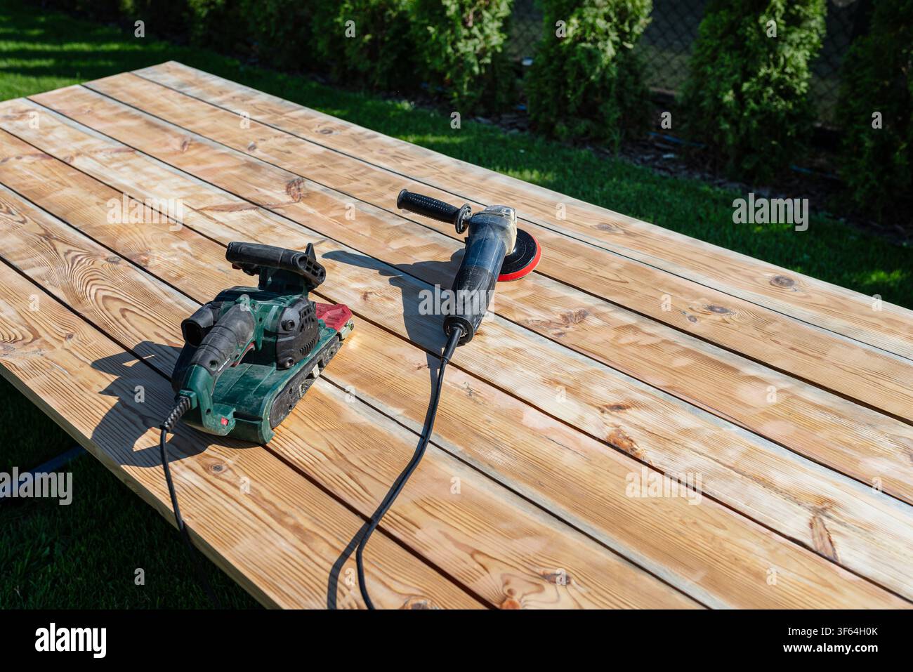 Renovierung einer alten HolzTISCHFLÄCHE im Freien mit leistungsstarken Schleifmaschinen Stockfoto