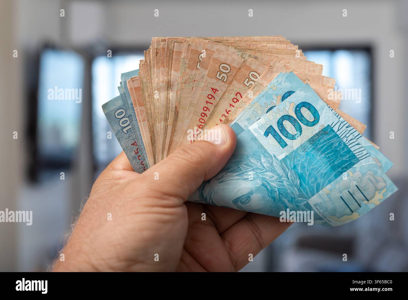 Brasilianische Real-Banknoten in der Hand mit selektiver Fokussierung Stockfoto