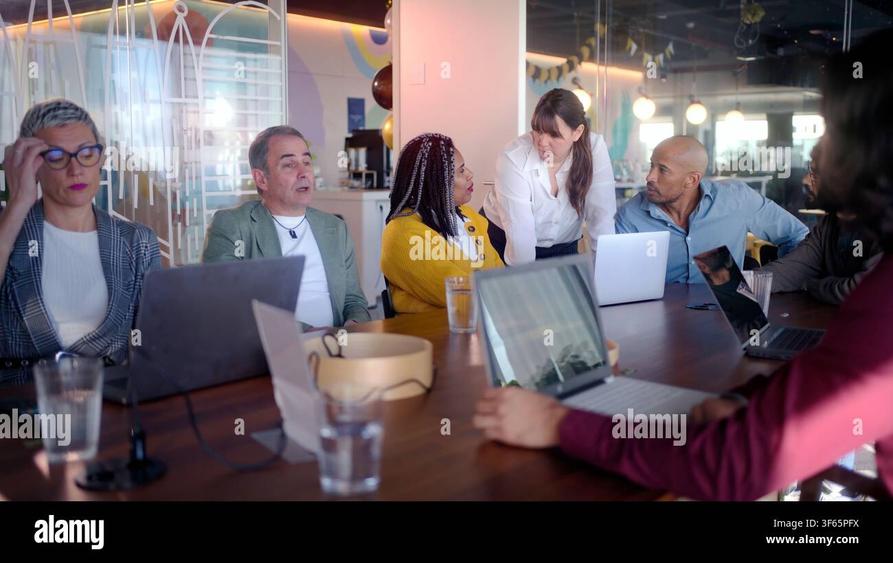 Geschäftsteam analysiert Daten auf Laptops während der Besprechung in modernen Büros Stockfoto