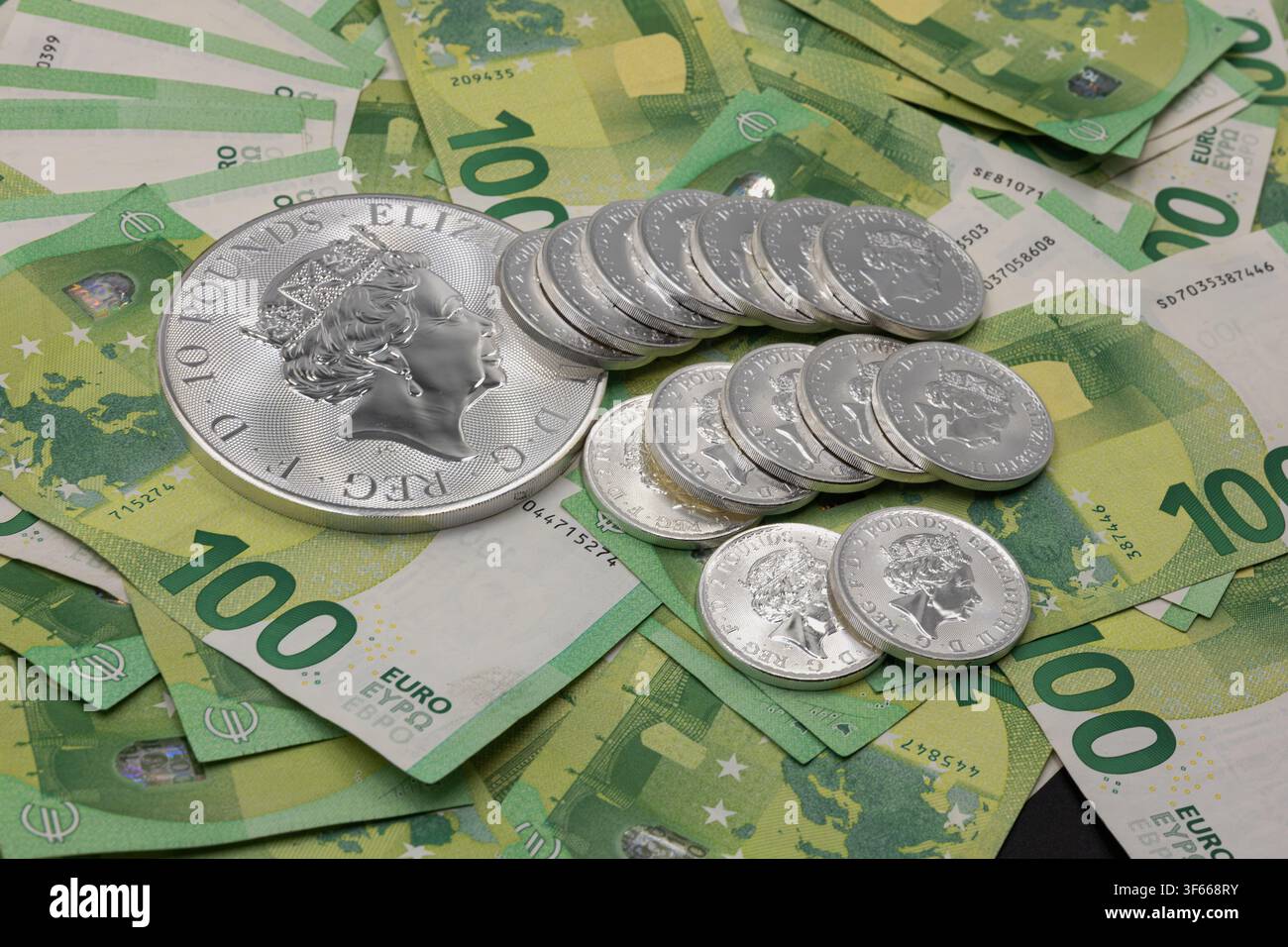 Silberbarrenmünzen auf Euro-Banknoten, die Investition, Wohlstand und finanzielle Sicherheit darstellen Stockfoto