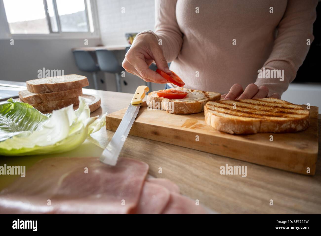 Zubereitung eines gegrillten Schinkensandwiches mit frischen Zutaten zu Hause Stockfoto
