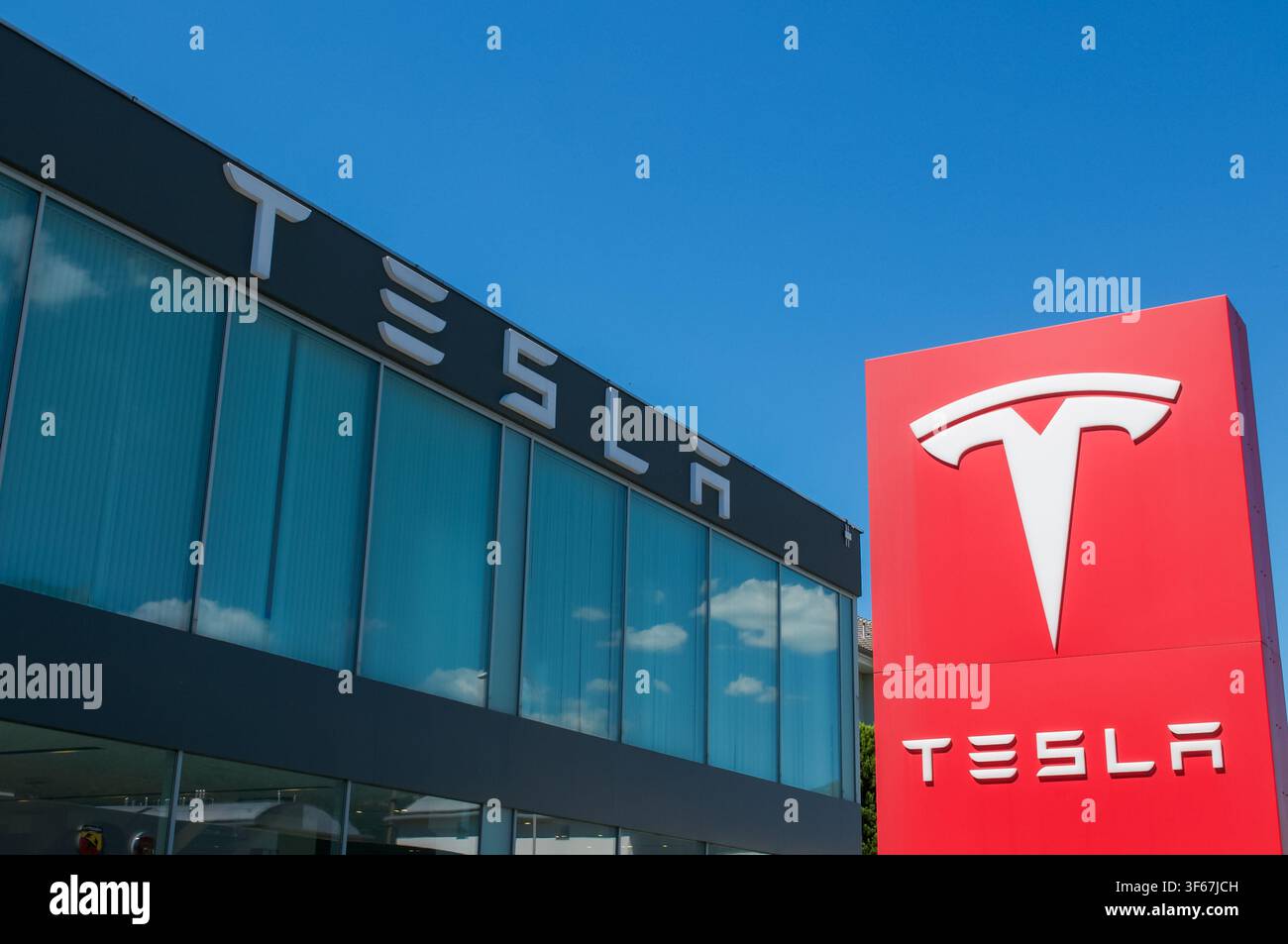 Cadenazzo, Tessin, Schweiz - 3. Juli 2026: Kombinierte Außenansicht eines offiziellen Tesla-Geschäfts- und Servicezentrumsgebäudes in Cadenazzo, Tessin Stockfoto