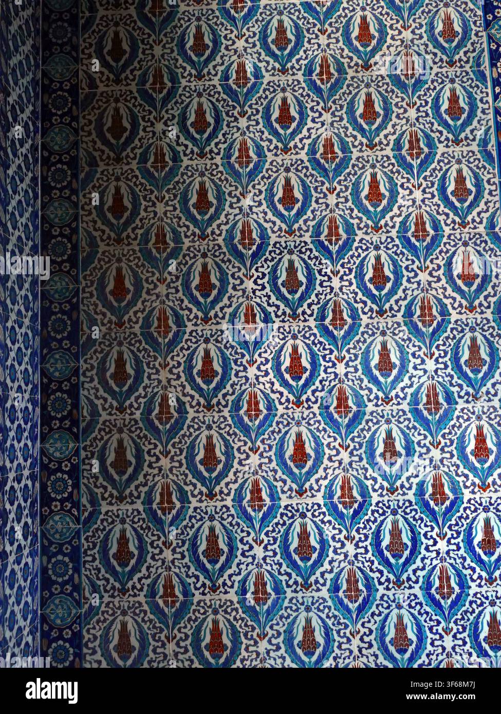 Istanbul - 24. Sep. 2024 - Nahaufnahme einer Wand, die mit traditionellen osmanischen Keramikfliesen bedeckt ist, die ein faszinierendes Blumenmuster in Schattierungen von Stockfoto