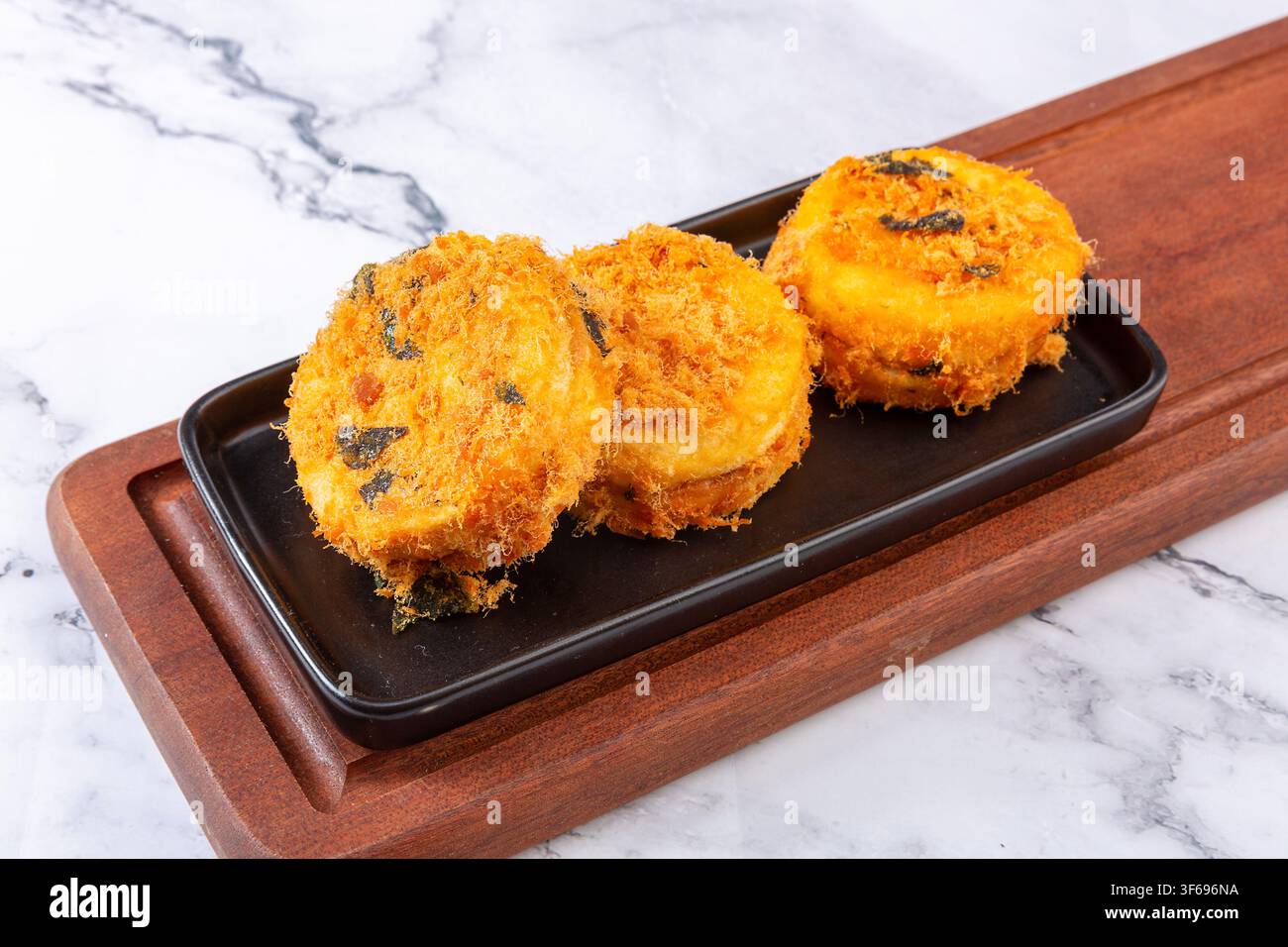 Weiche runde Schwammkuchen, überzogen mit herzhafter Schweinefloss und Algenflocken Stockfoto
