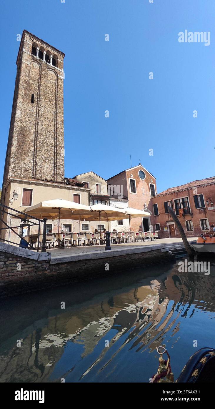 Stadtbild des Campanile von San Giacomo dell'Orio und Kanalreflexionen in Venedig, Italien - Smartphone-aufgenommenes Stockfoto