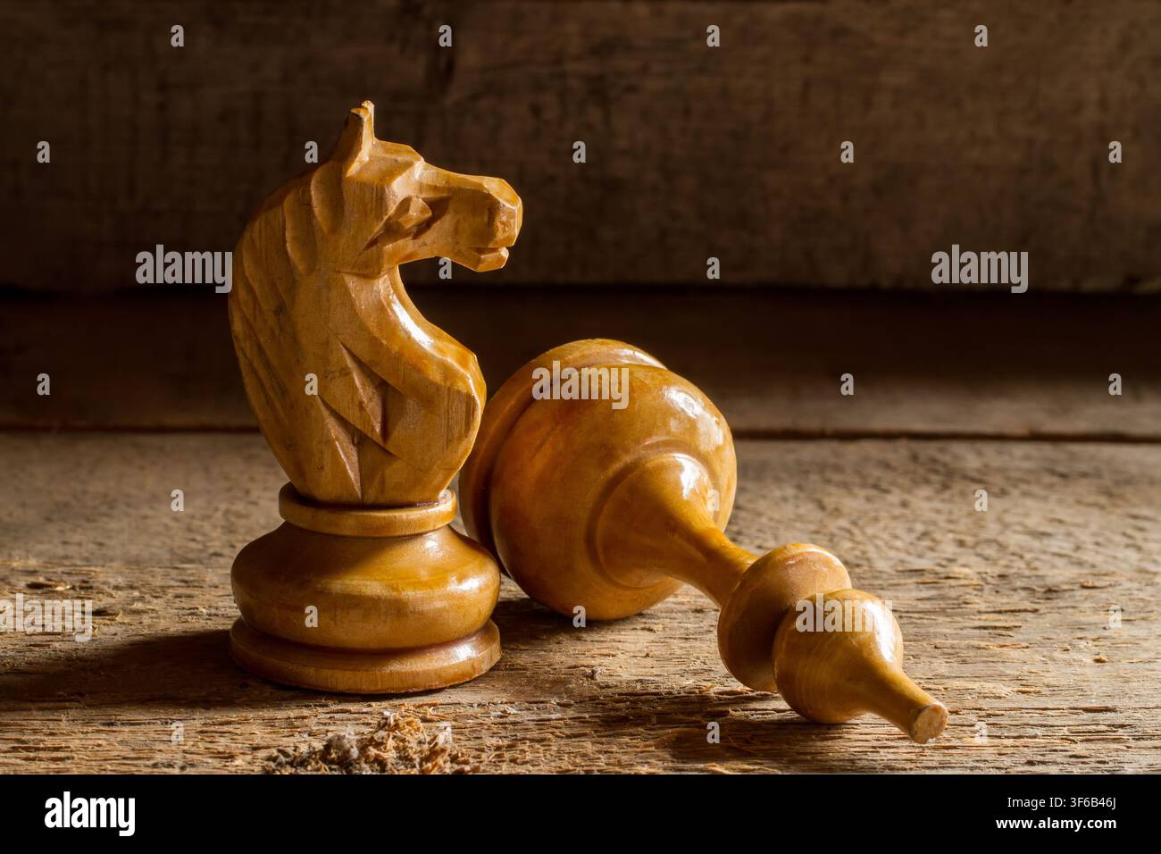 Holzschachfiguren. Alter Schachritter und Bischof. Eine Figur liegt. Stockfoto