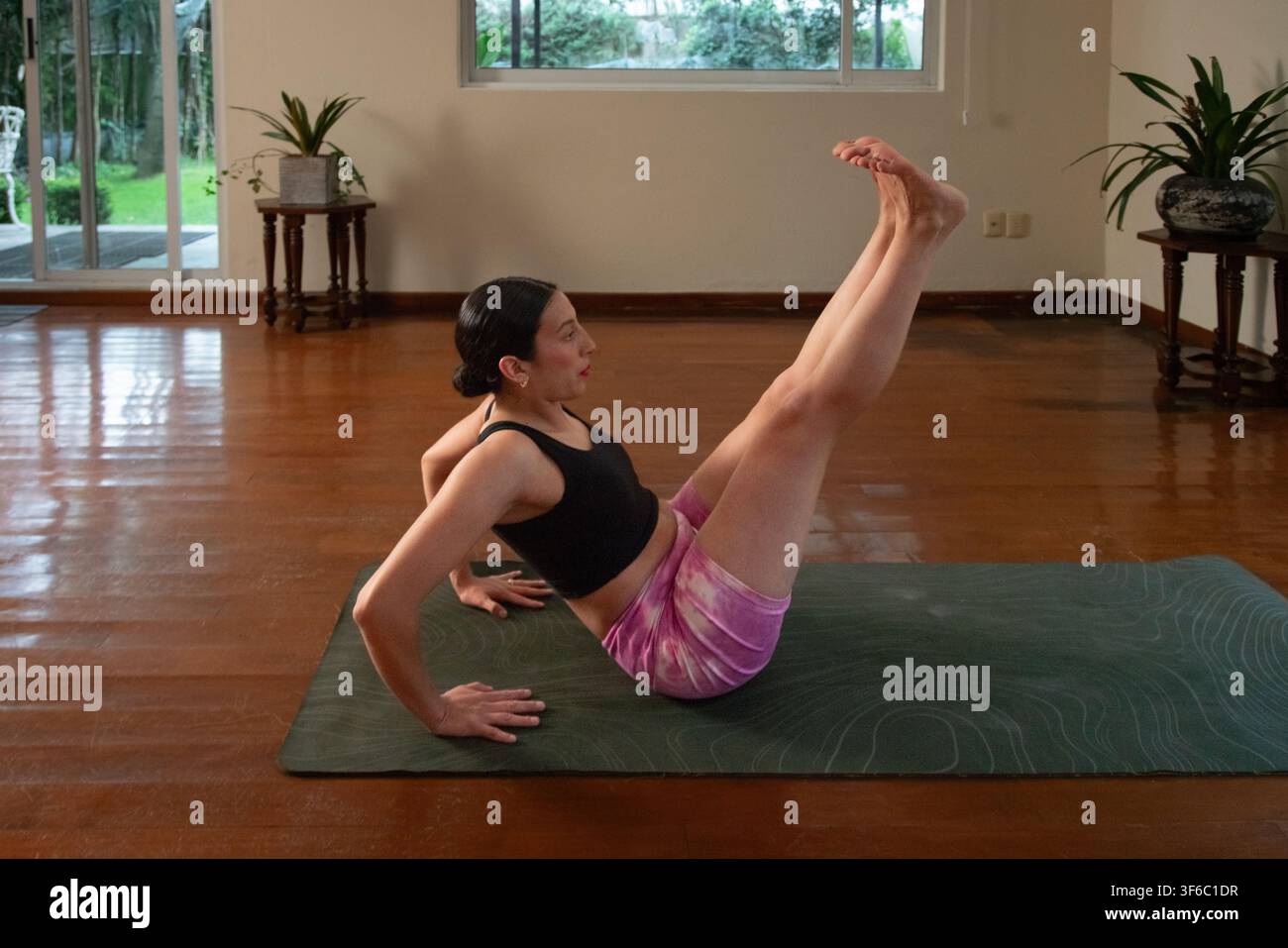 Frau macht Bootspose Yoga zu Hause Stockfoto