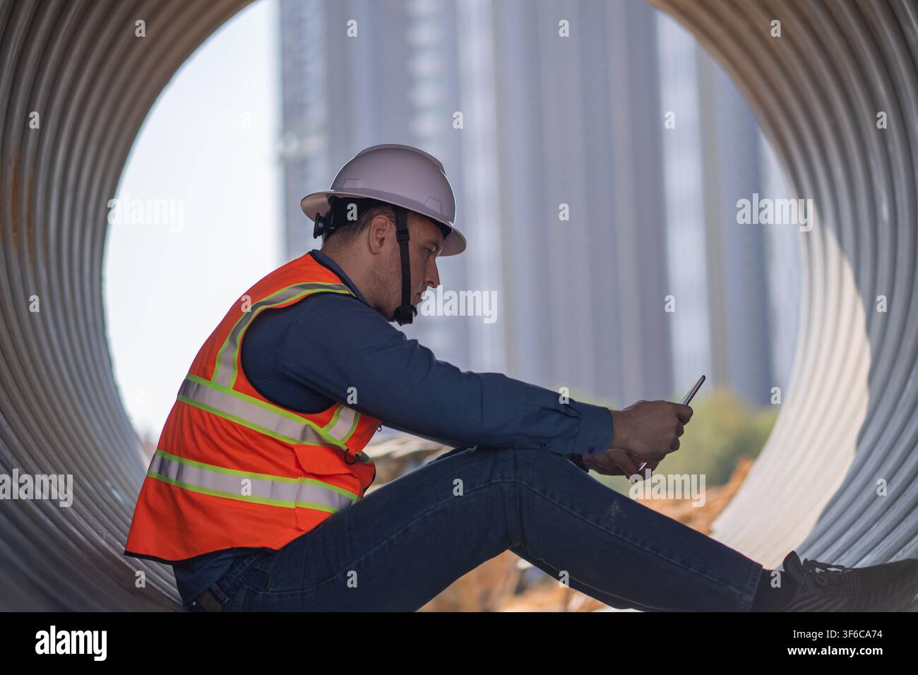 Bauleiter oder Ingenieur arbeitet auf einer Rohrbaustelle zur Inspektion von Baudetails mit schweren Maschinen Stockfoto