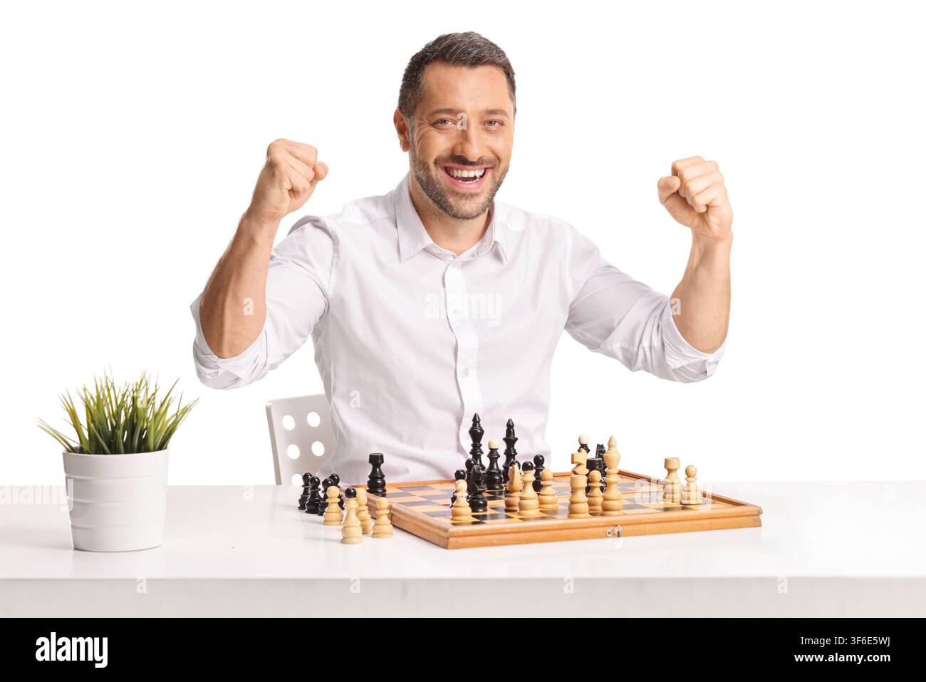 Mann lächelt und feiert Sieg in einem Schachspiel, isoliert auf weißem Hintergrund Stockfoto