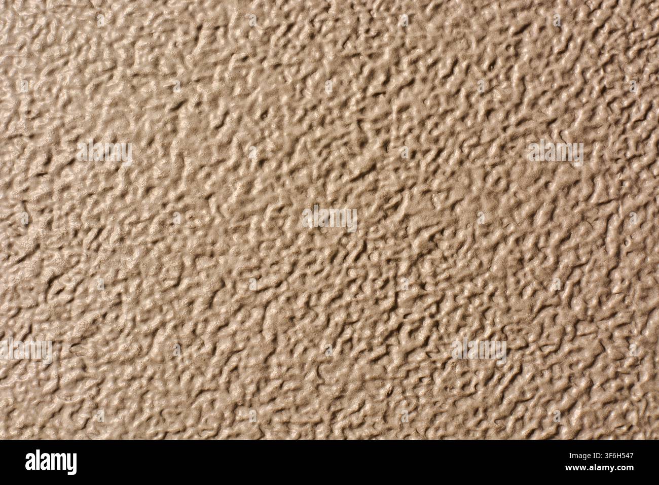 beiger strukturierter Oberflächenhintergrund, raues, holpriges Muster und körniges hellbraunes Finish, Nahaufnahme im vollen Bild, Konzept für industrielles Material oder Wanddesign Stockfoto