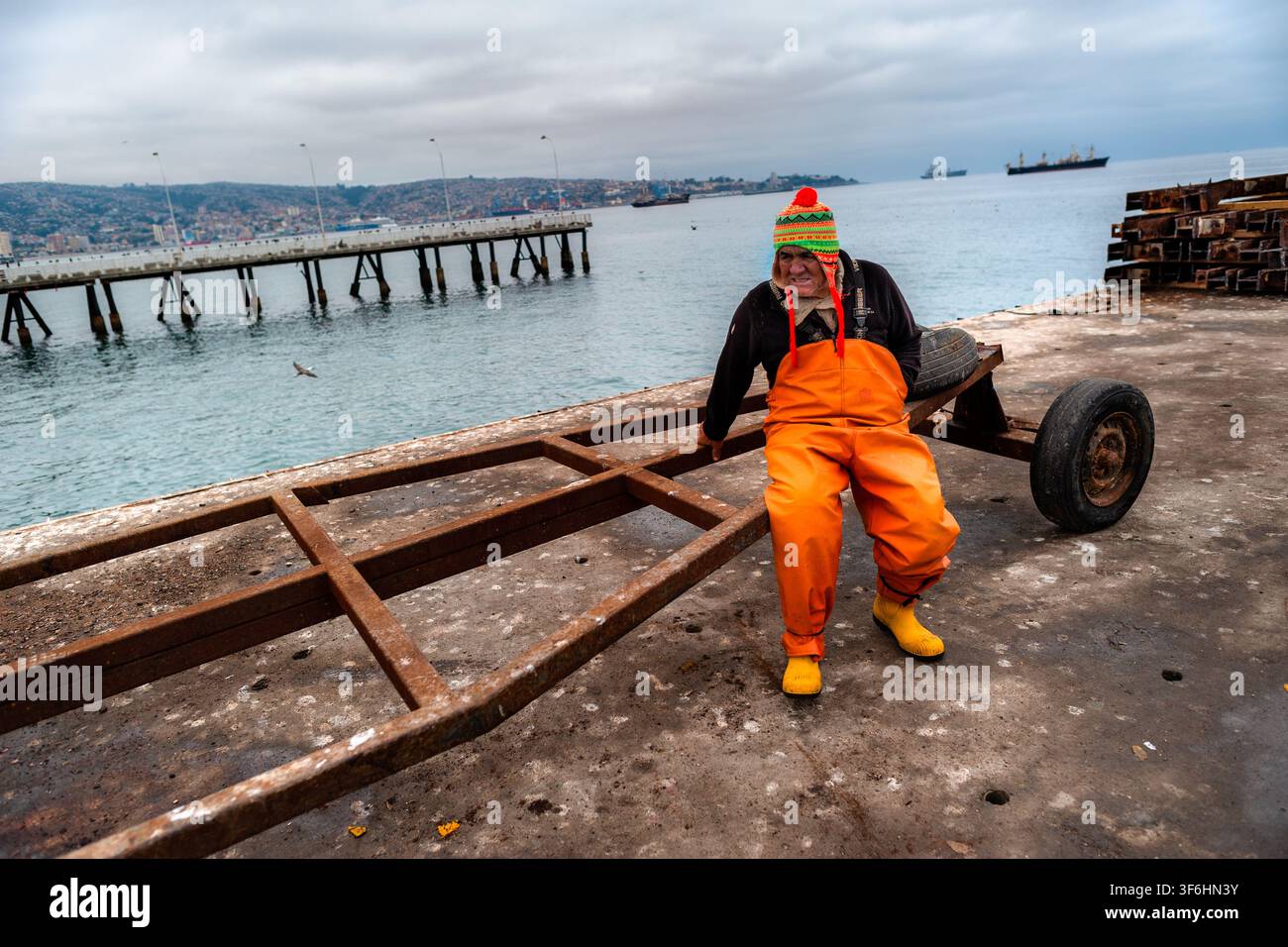 Ein chilenischer Fischer ruht auf einem Bootswagen in Caleta Portales, einem traditionellen Fischereihafen in Valparaíso, Chile. Stockfoto