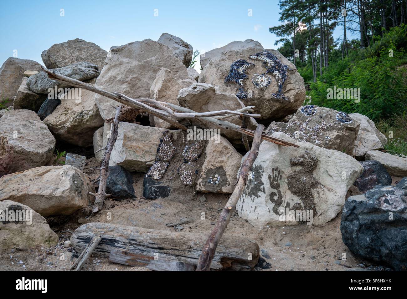 Naturinspirierte Felskunst-Installation mit Muschel-Mosaik in einer Waldumgebung Stockfoto