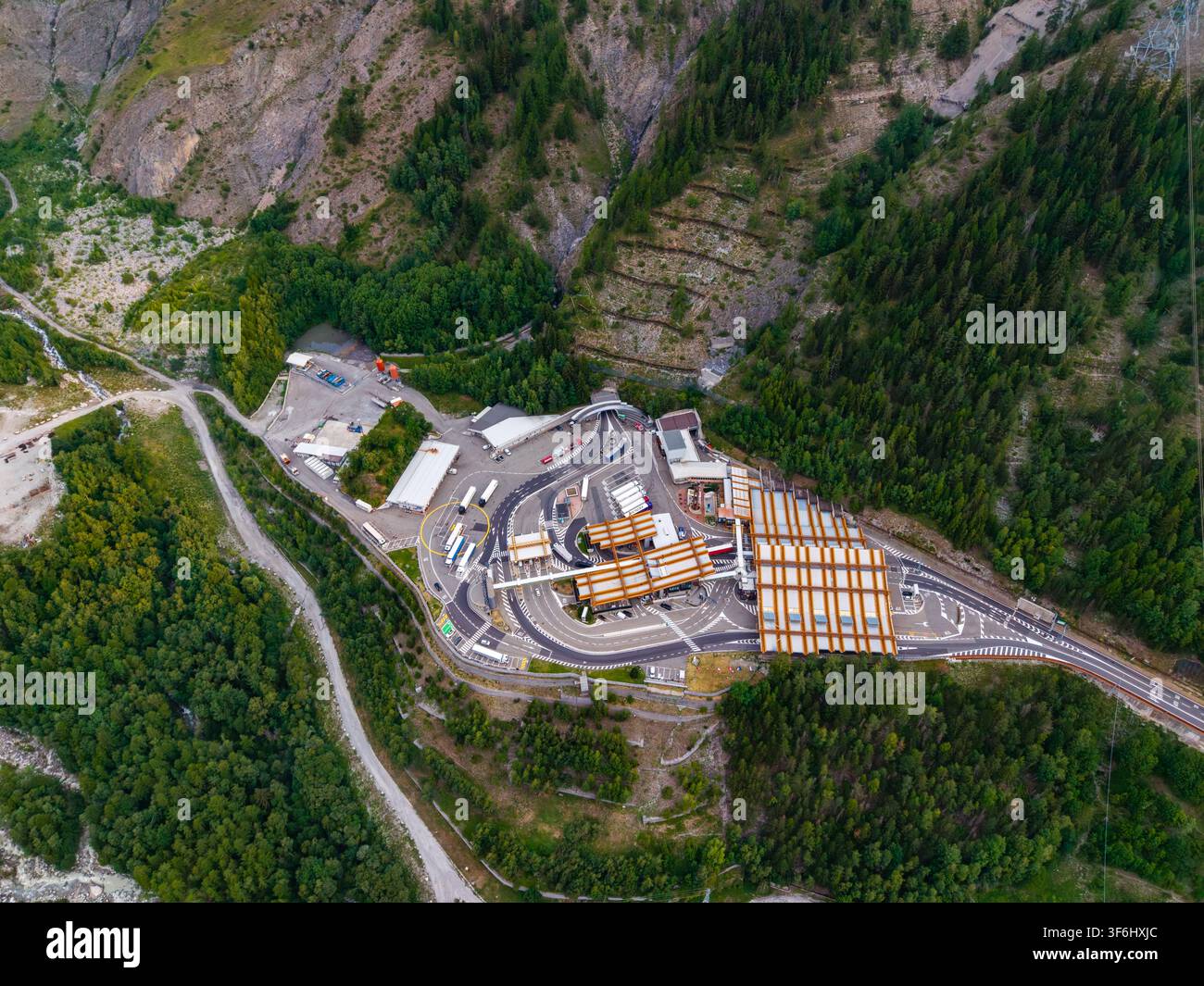 Luftbild des Eingangs zum Mont-Blanc-Tunnel mit seiner Mautstation, umliegenden Nadelwäldern und Berggelände in Courmayeur, Valle d'Aosta Stockfoto
