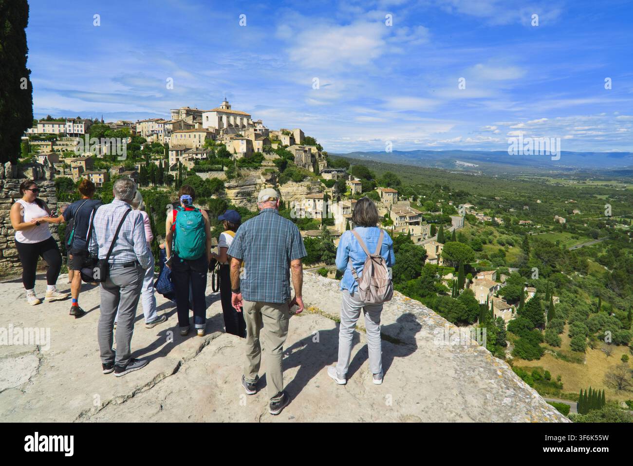 Touristen bewundern das malerische Hügeldorf Gordes von einem Aussichtspunkt in der Provence, Frankreich. Stockfoto