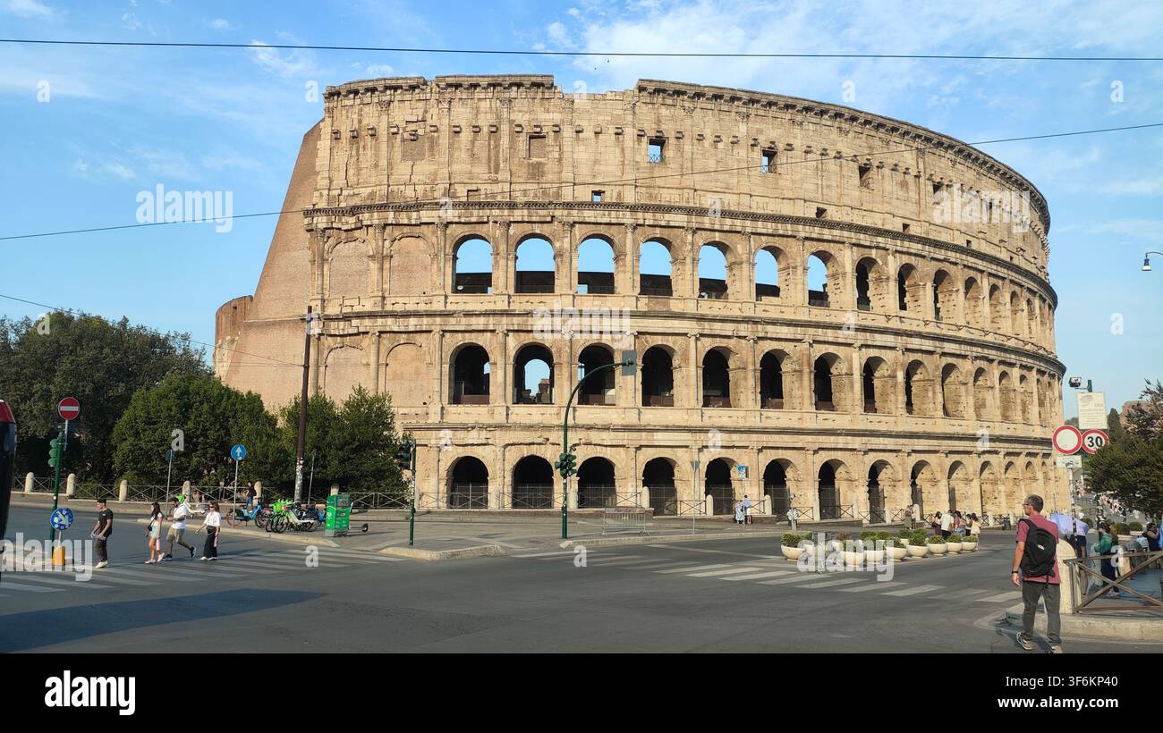 Colosseum-Außenansicht bei goldenem Morgenlicht, Rom Italien  Antike römische Amphitheater-Strassenansicht - Smartphone-aufgenommenes Stockfoto
