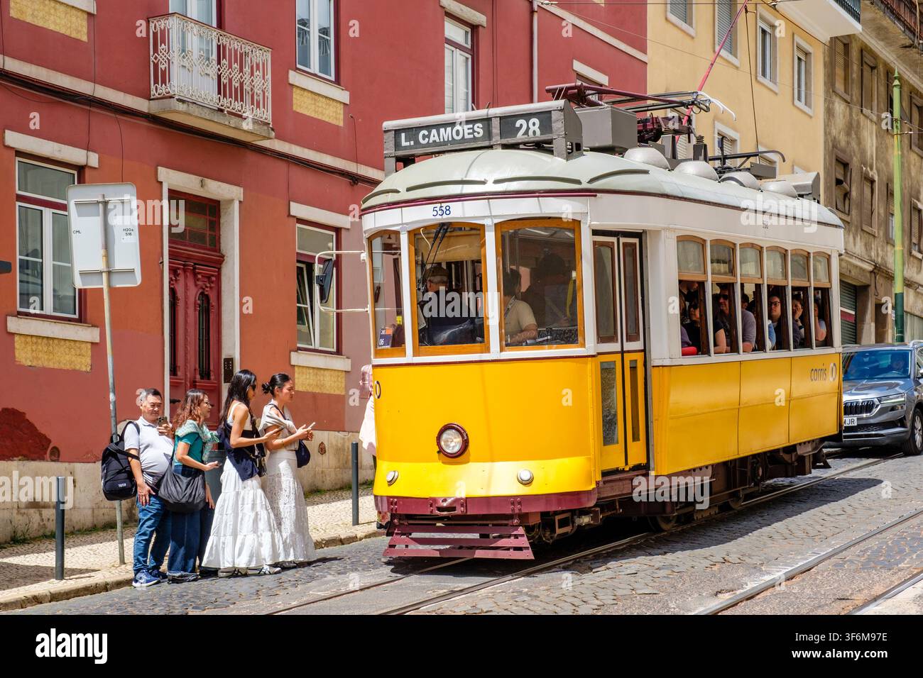 Passagiere steigen in die gelbe Straßenbahn der Linie 28 in der Stadt Lissabon, Portugal Stockfoto
