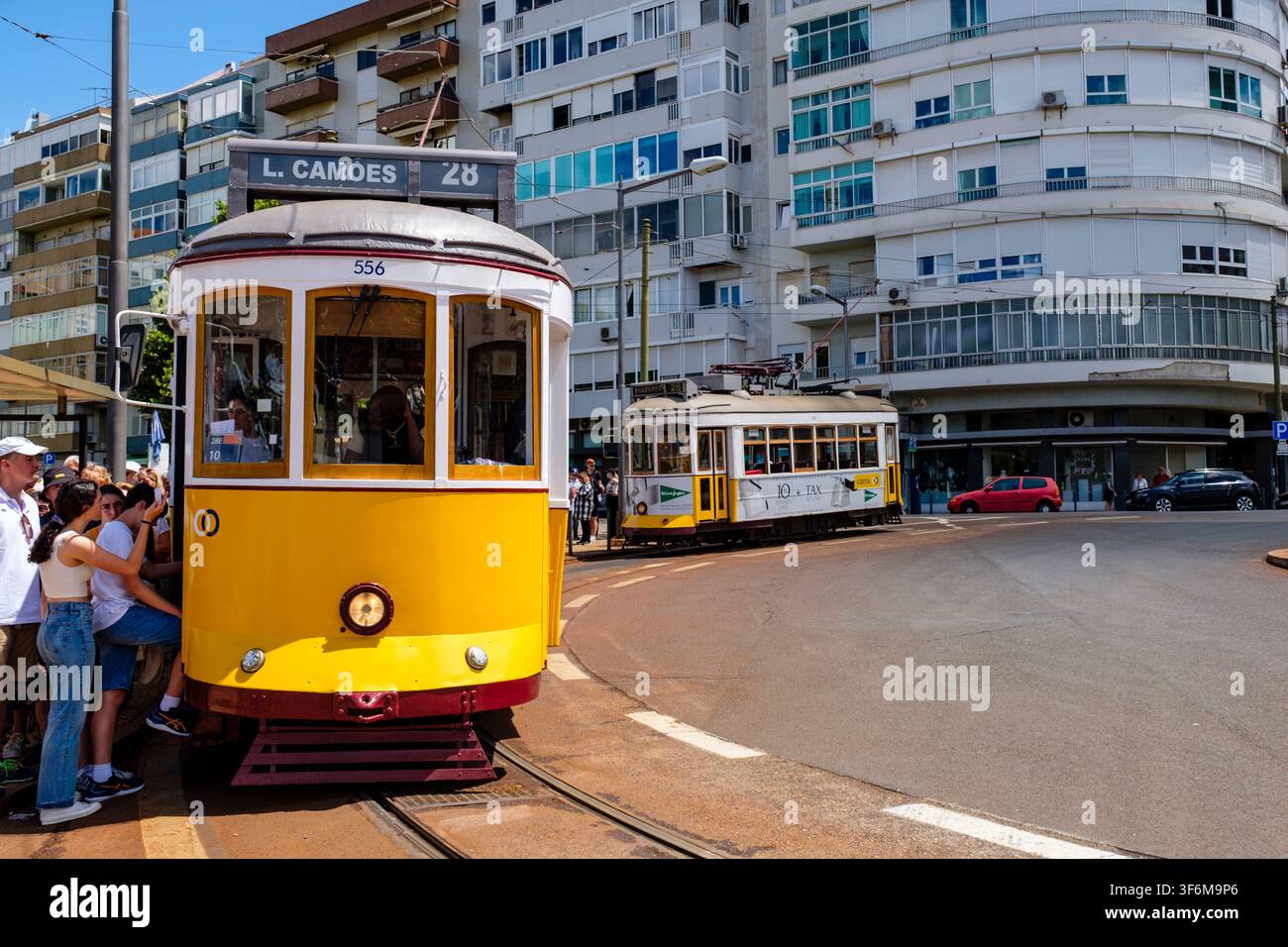 Passagiere steigen in die gelbe Straßenbahn der Linie 28 in der Stadt Lissabon, Portugal Stockfoto