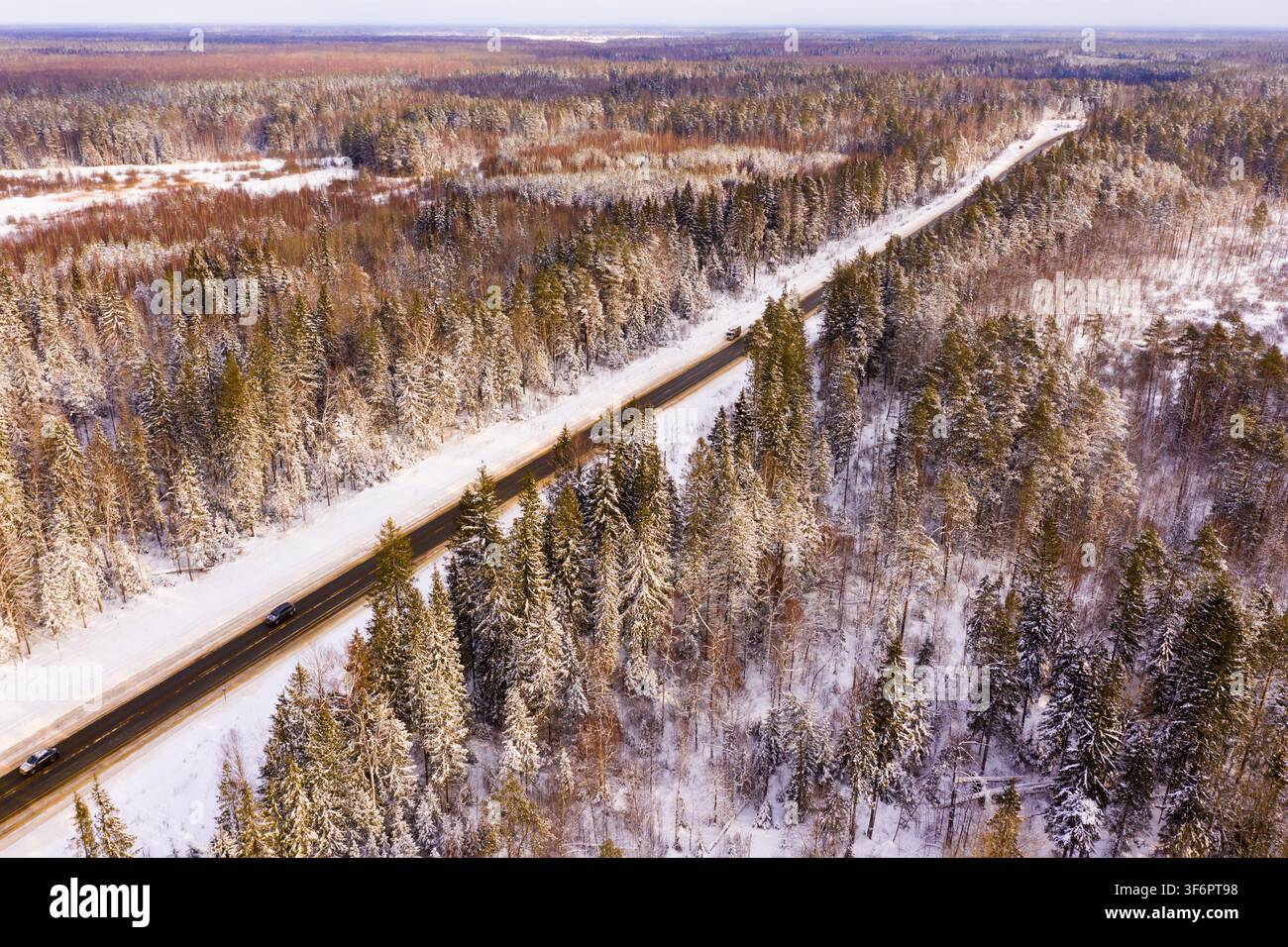 Direkte Straße durch den Winterwald. Blick von oben Stockfoto