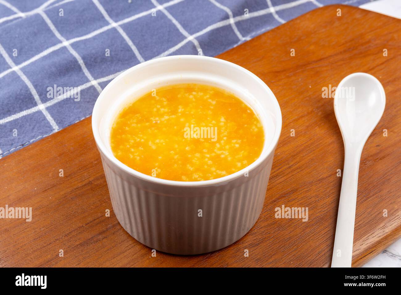 Goldener Hirse-Kürbisbrei garniert mit getrockneten Goji-Beeren Stockfoto