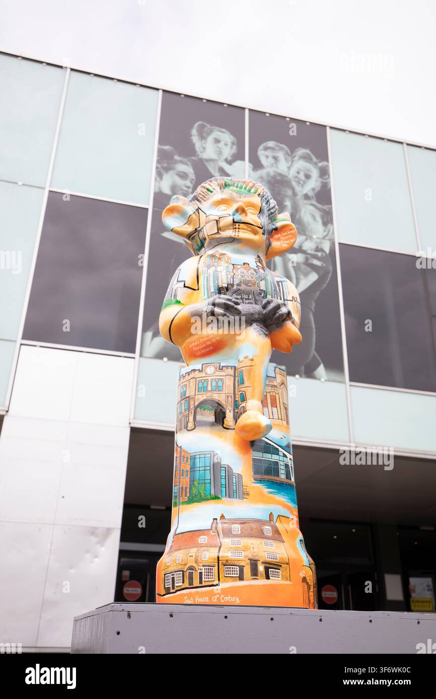 Die bemalte Skulptur „Lincoln's History“ des Imp, die Wahrzeichen der Stadt illustriert, ausgestellt vor einem modernen gläsernen Einkaufszentrum während des Imp Trail, UK. Stockfoto