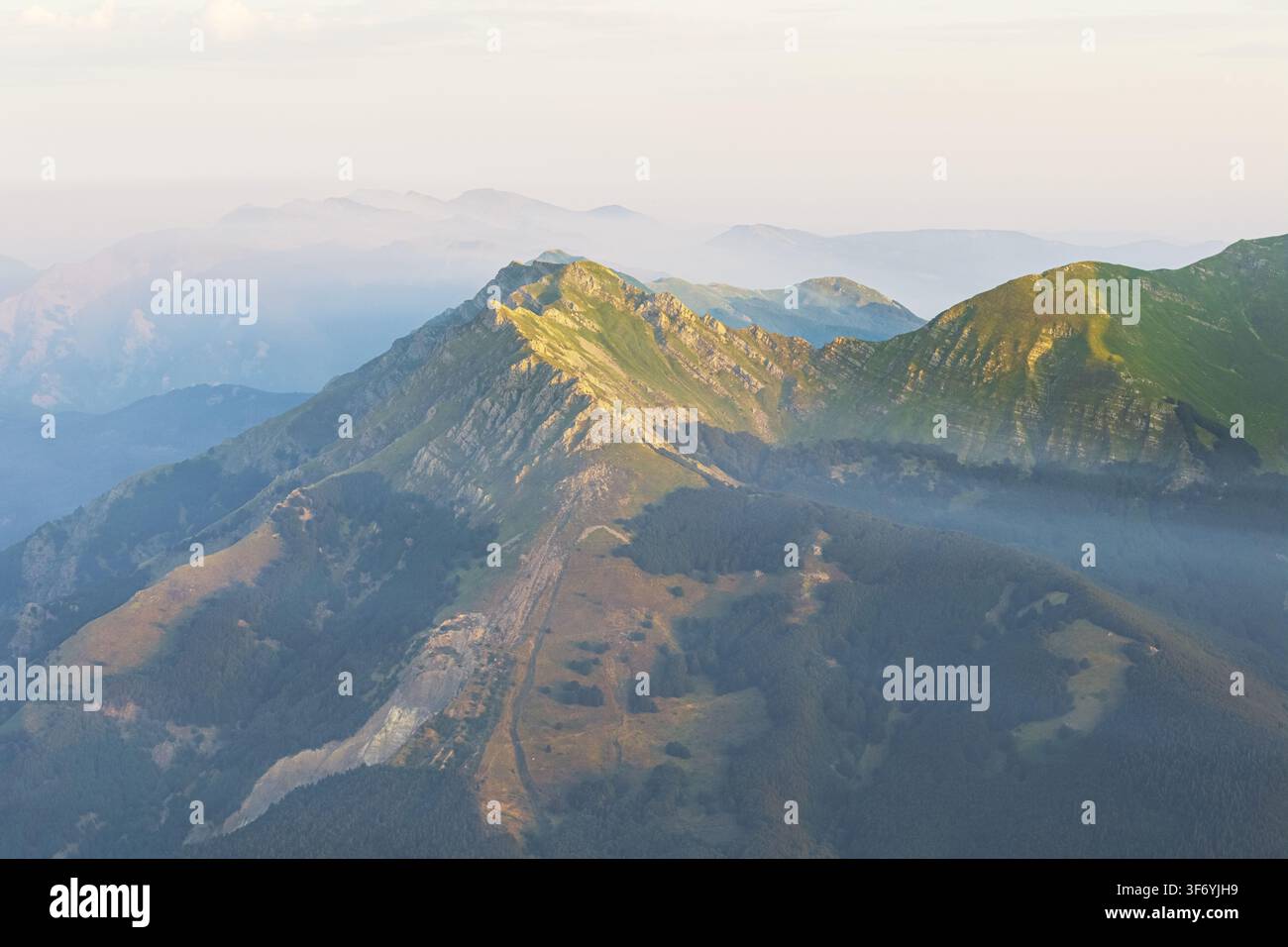 Luftaufnahme der schroffen Gipfel und grünen Hänge des Cerreto Laghi-Gebiets in den Appennino Tosco-Emiliano-Bergen zur goldenen Stunde in Cerreto Laghi Stockfoto