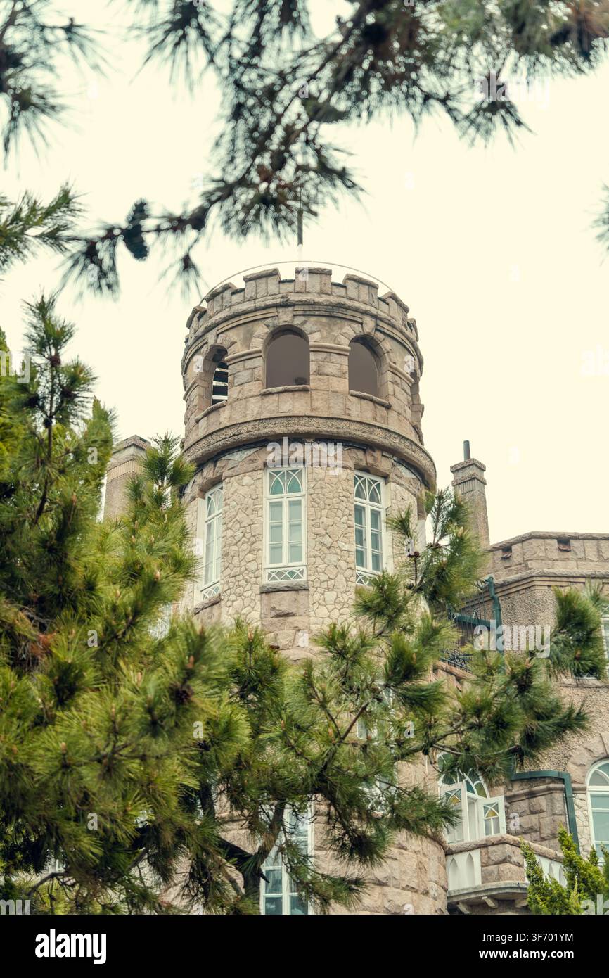 Runder steinerner Turm mit Zinnen im Huashi-Lou-Schloss, Badaguan, Qingdao, China Stockfoto