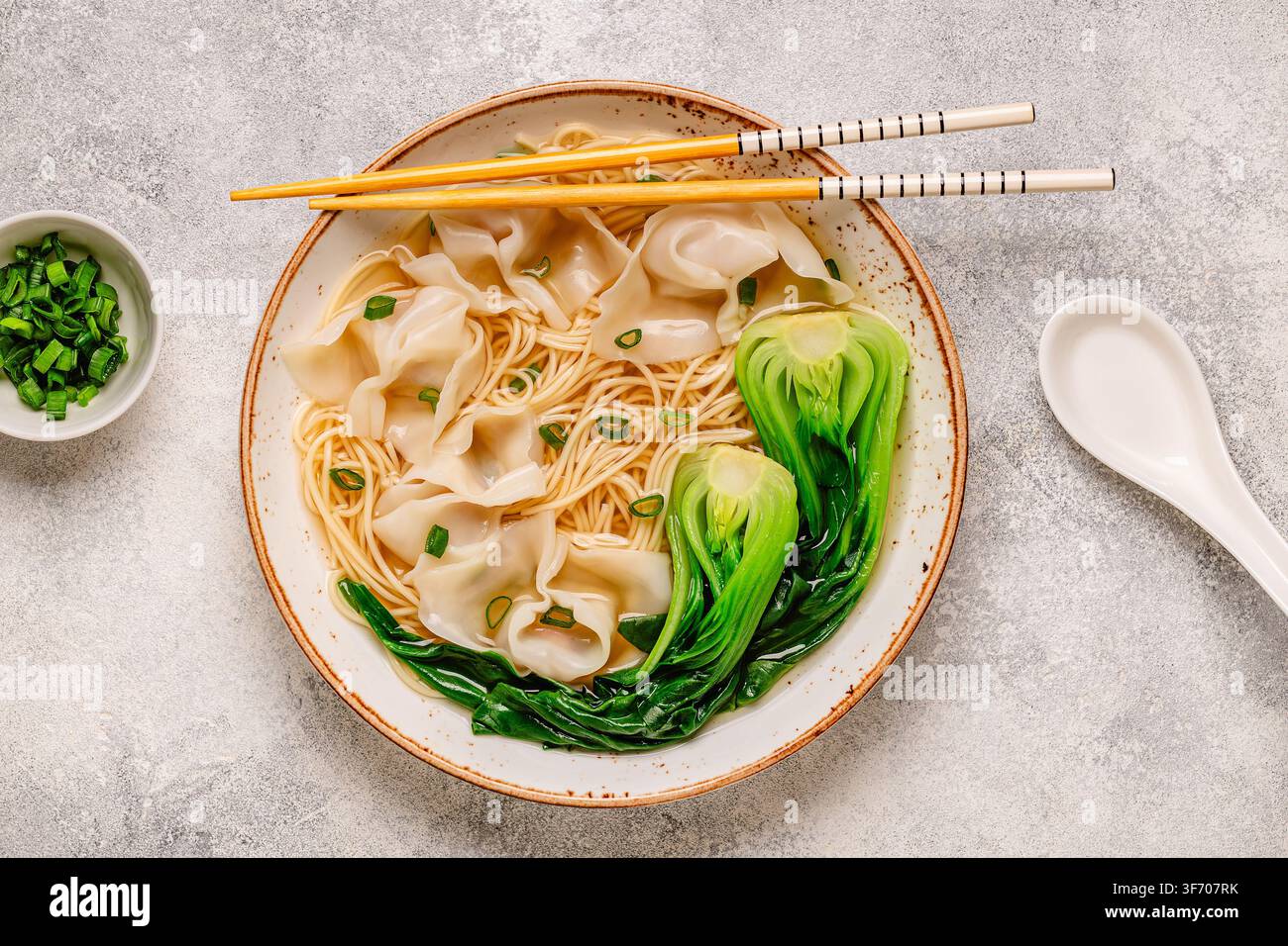 Warme Nudelsuppe mit Knödeln (Wontons) und Kohl-Bok Choy in einer Schüssel serviert. Stockfoto