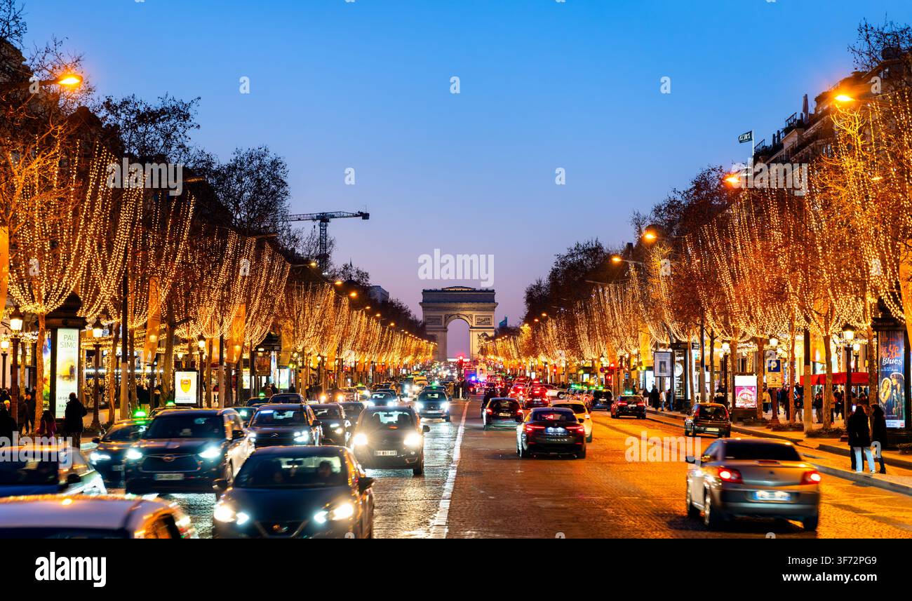 Paris, Frankreich - 25. Dezember 2025: Der Verkehr fließt entlang der beleuchteten Champs-Elysées-Avenue in Richtung des Arc de Triomphe während der Weihnachtsfeiertage Stockfoto
