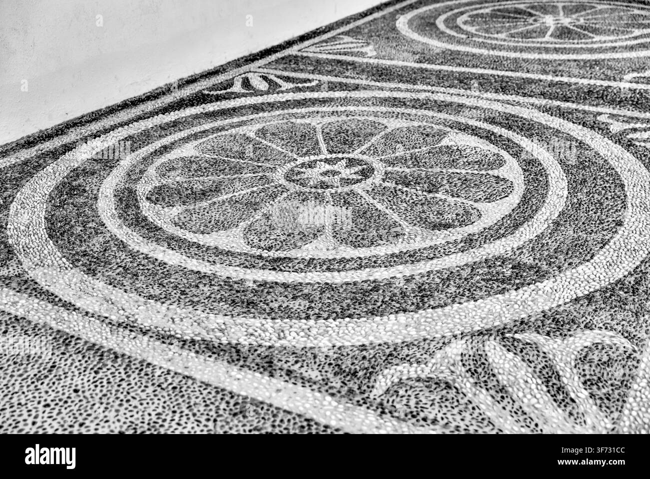 Dekorativer Mosaikboden aus Kieselsteinen mit kreisförmigen geometrischen Mustern im Topkapı-Palast in Istanbul, Türkiye. Stockfoto