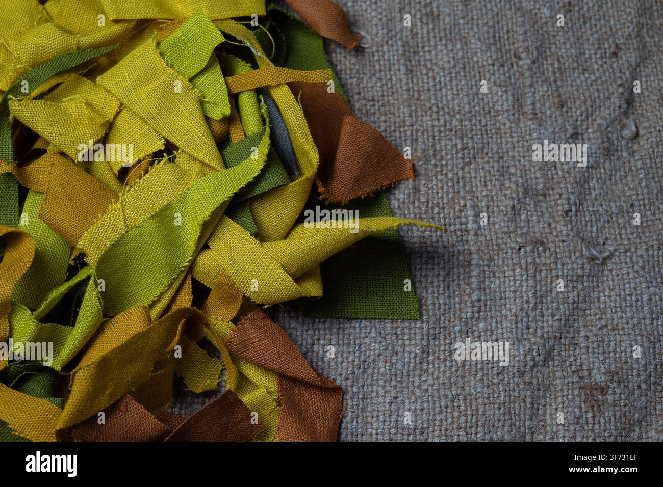 Bunte Stoffreste auf Sackleinenhintergrund mit Kopierraum, nachhaltiges Textilkonzept Stockfoto