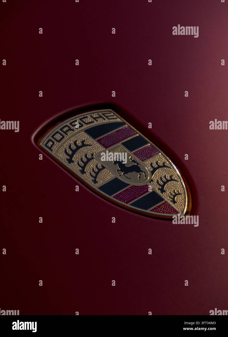 Nahaufnahme des Porsche-Logo-Emblems, das auf der Motorhaube eines Luxus-Sportwagens montiert ist. Stockfoto