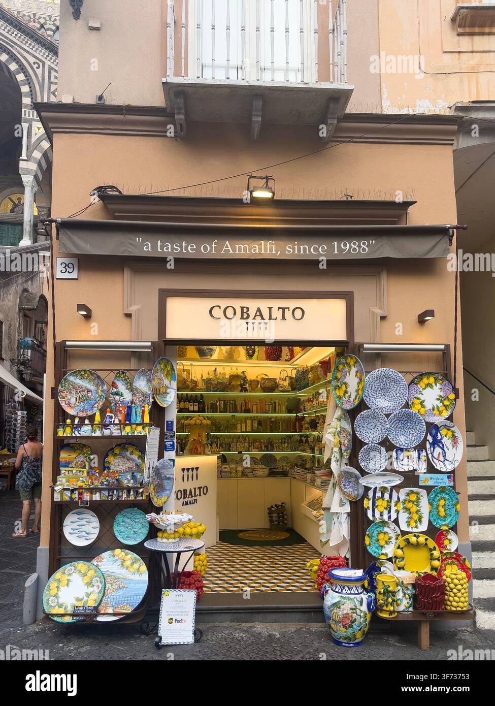 Cobaltkeramikgeschäft in Amalfi, Italien, das farbenfrohe handbemalte Töpferwaren, Zitronenkeramik und traditionelle Souvenirs der Amalfiküste ausstellt. - Smartphone-aufgenommenes Stockfoto