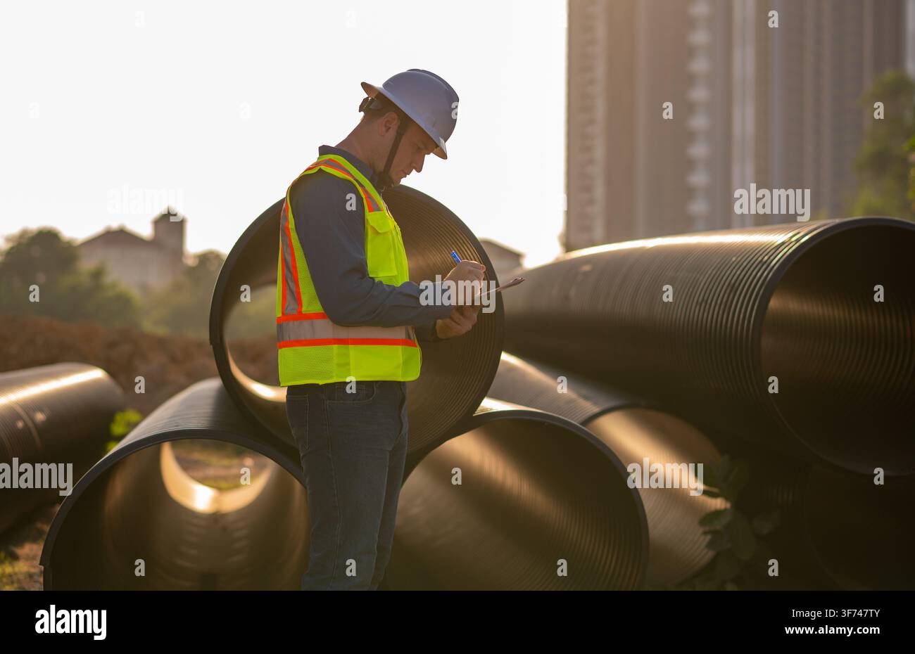 Bauleiter oder Ingenieur arbeitet auf einer Rohrbaustelle zur Inspektion von Baudetails mit schweren Maschinen Stockfoto