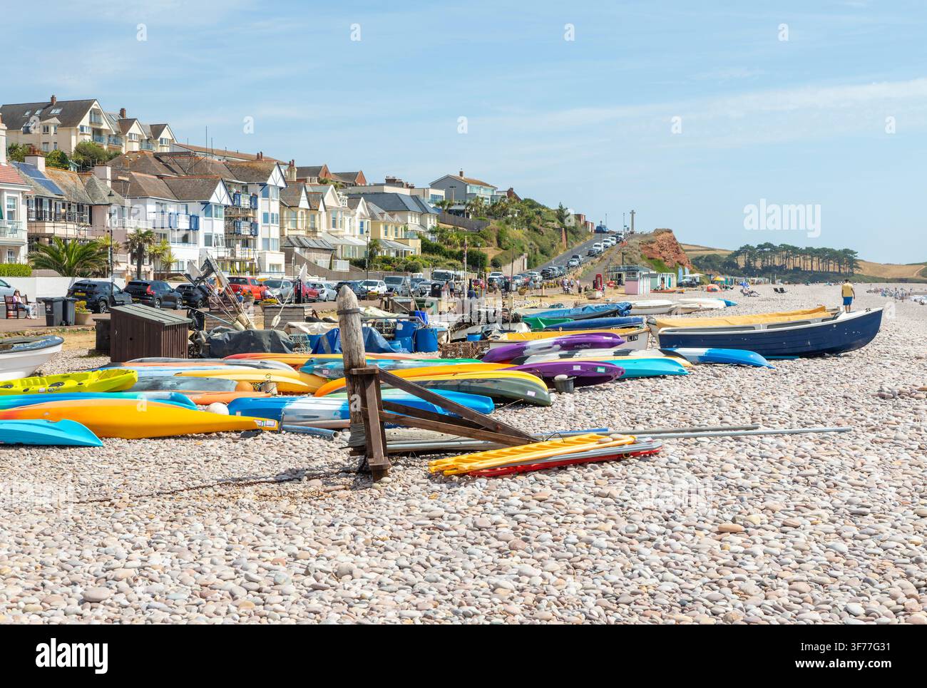 Boote und umgedrehte Kajaks an einem Kiesstrand in Budleigh Salterton, Devon, England, UK Stockfoto